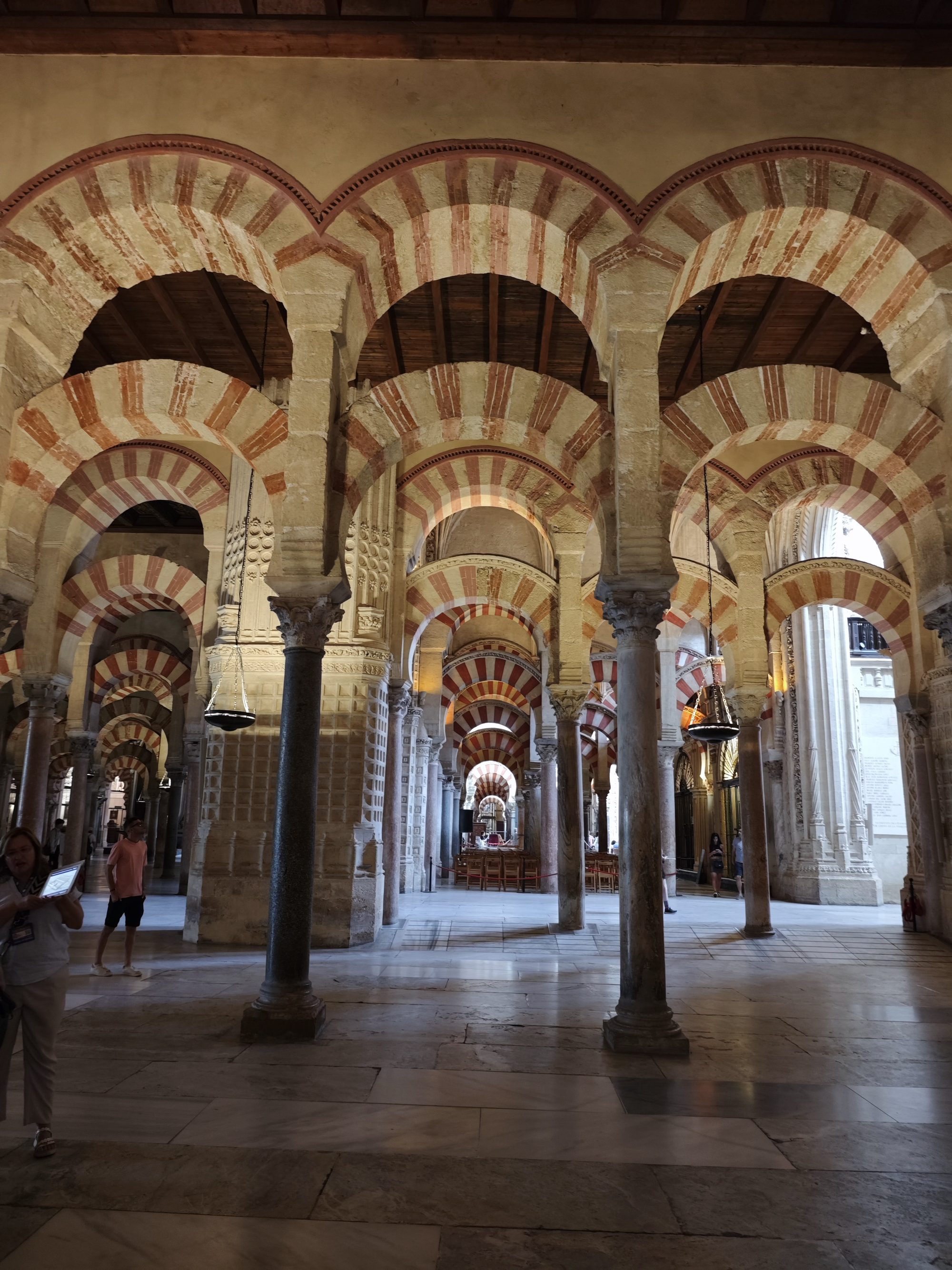 Arcos de herradura rojos y blancos apoyados sobre columnas en la Mezquita de Córdoba.