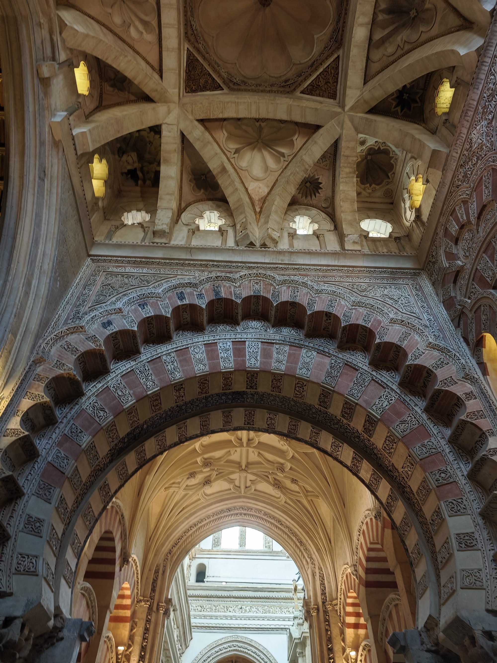 Arcos lobulados y cúpulas decoradas con intrincados relieves en la Mezquita de Córdoba.