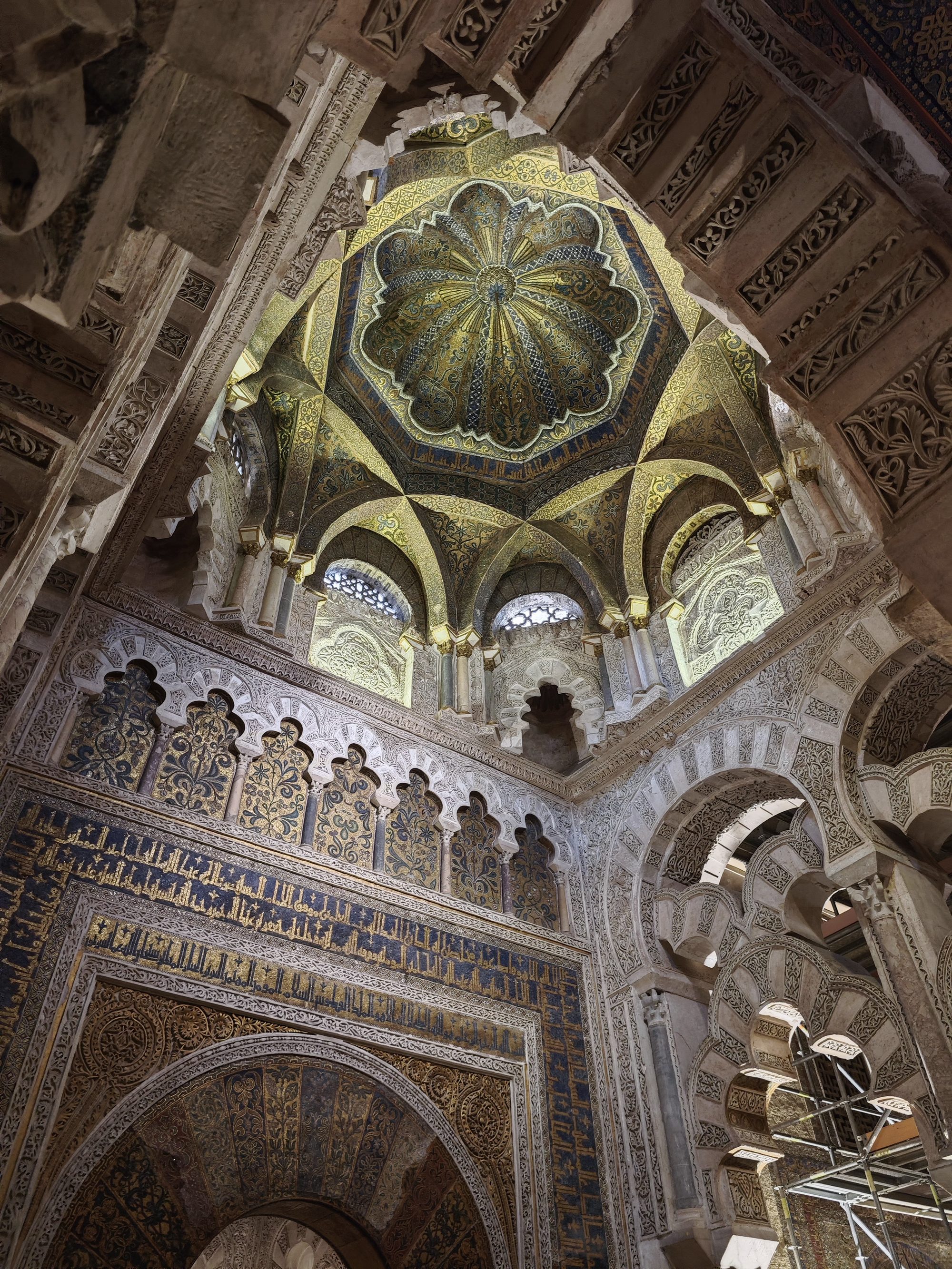 Cúpula dorada y arcos polilobulados con mosaicos e inscripciones en la Mezquita de Córdoba.