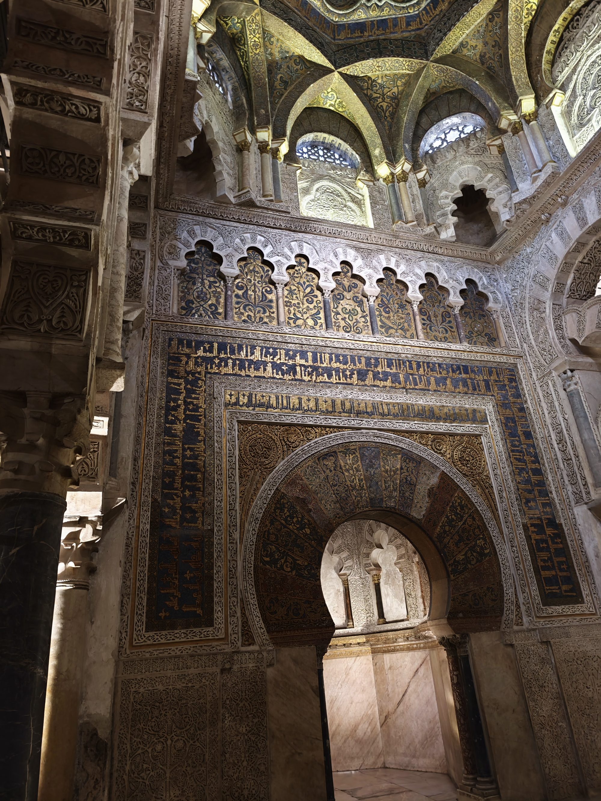 Detalle ornamental del mihrab con mosaicos dorados e inscripciones en la Mezquita de Córdoba.