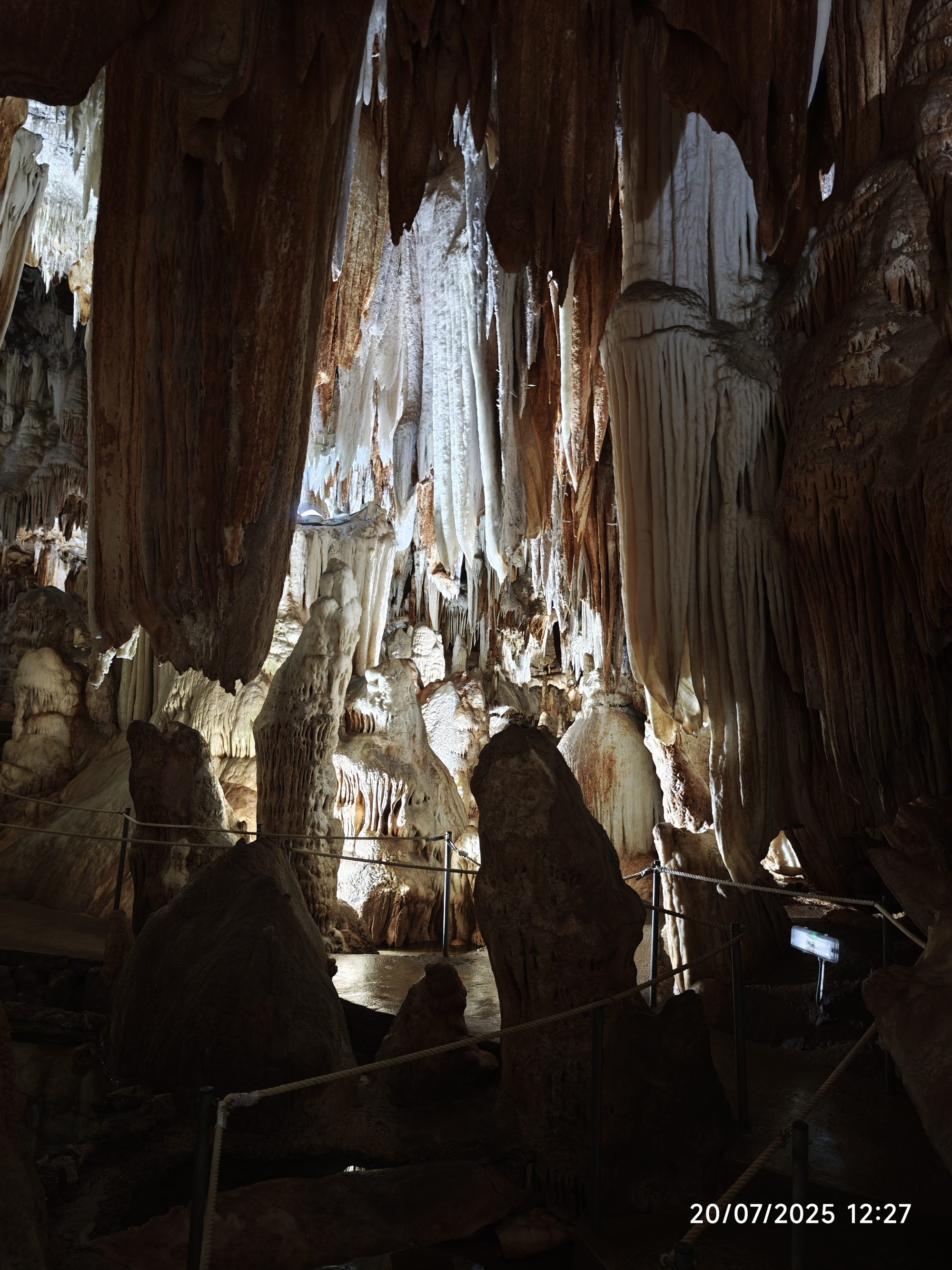 Espectaculares estalactitas y estalagmitas iluminadas en el interior de una cueva subterránea.