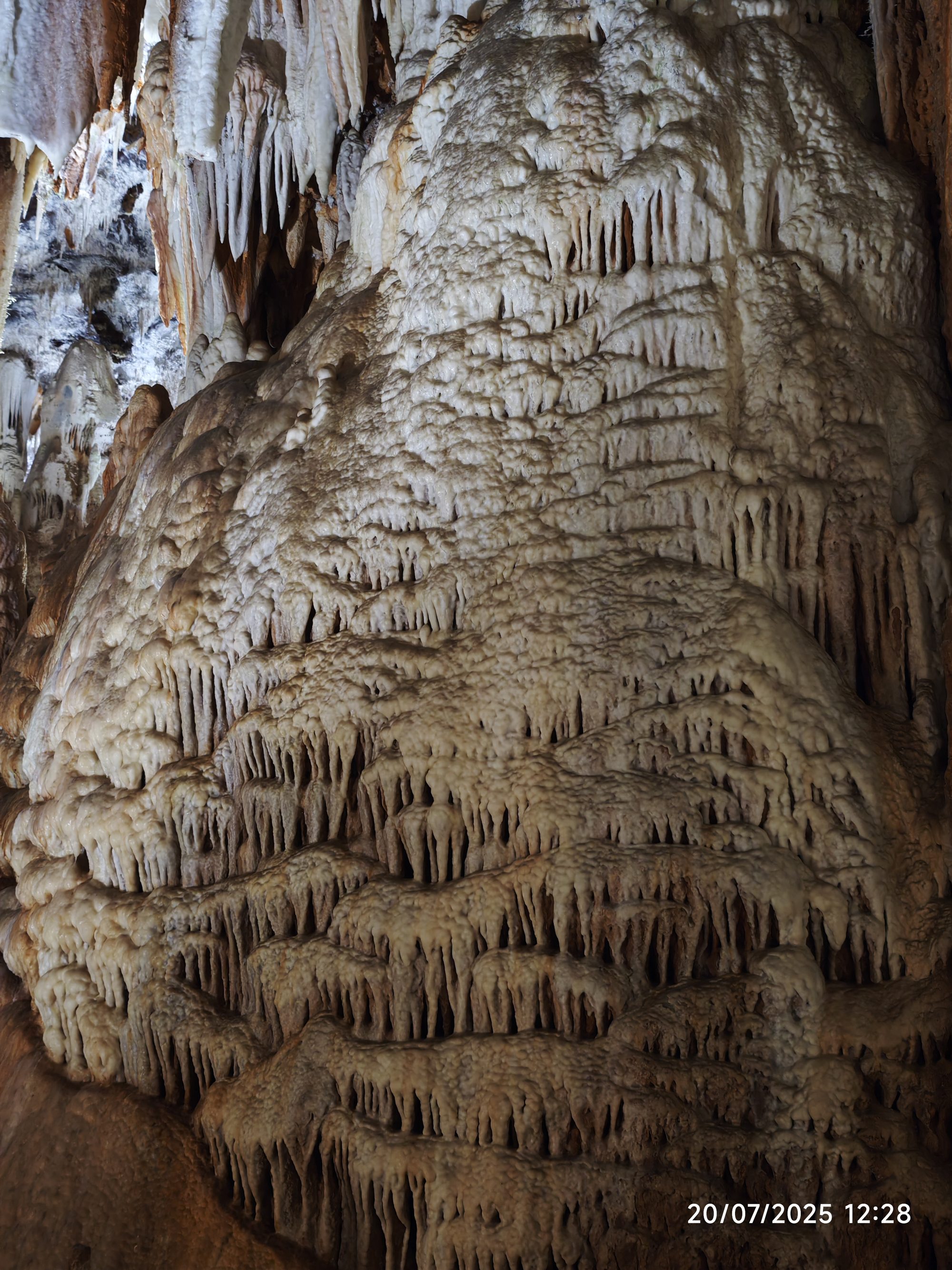 Impresionantes formaciones de estalactitas y estalagmitas de piedra caliza dentro de una cueva.