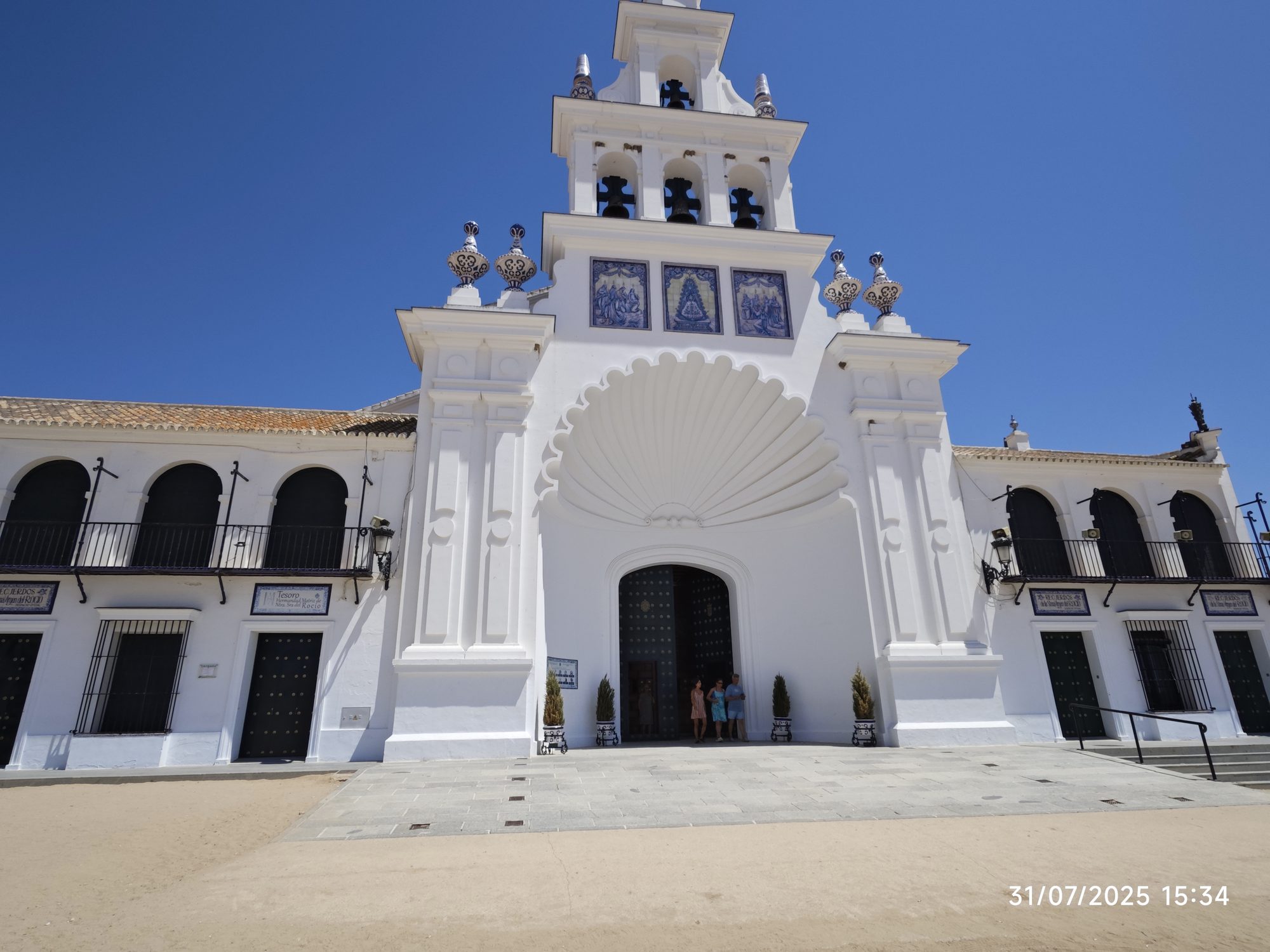 Fachada blanca de la Ermita del Rocío con campanario y gran arco de concha.