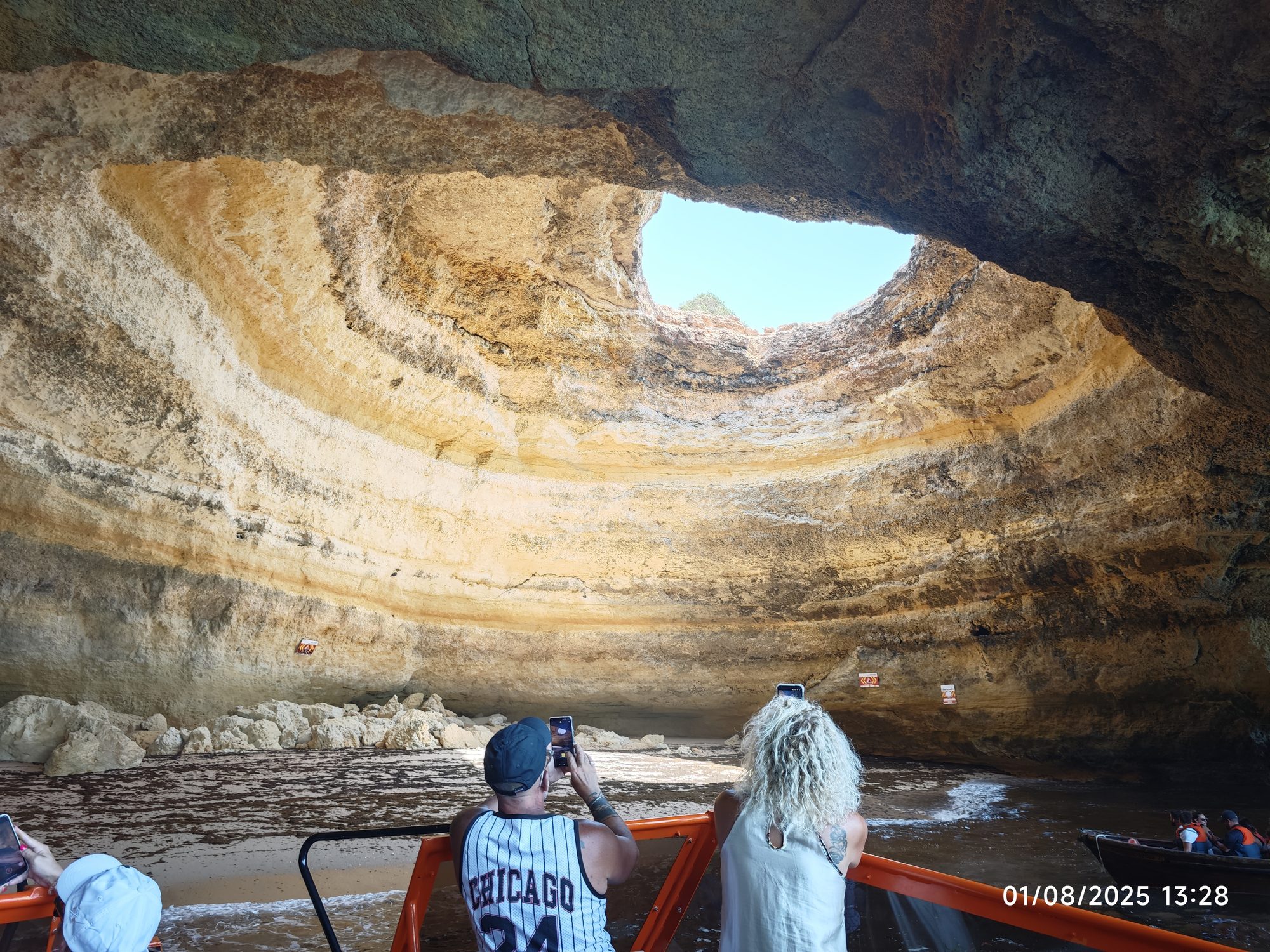 Interior de la cueva de Benagil con una apertura circular en su techo rocoso.