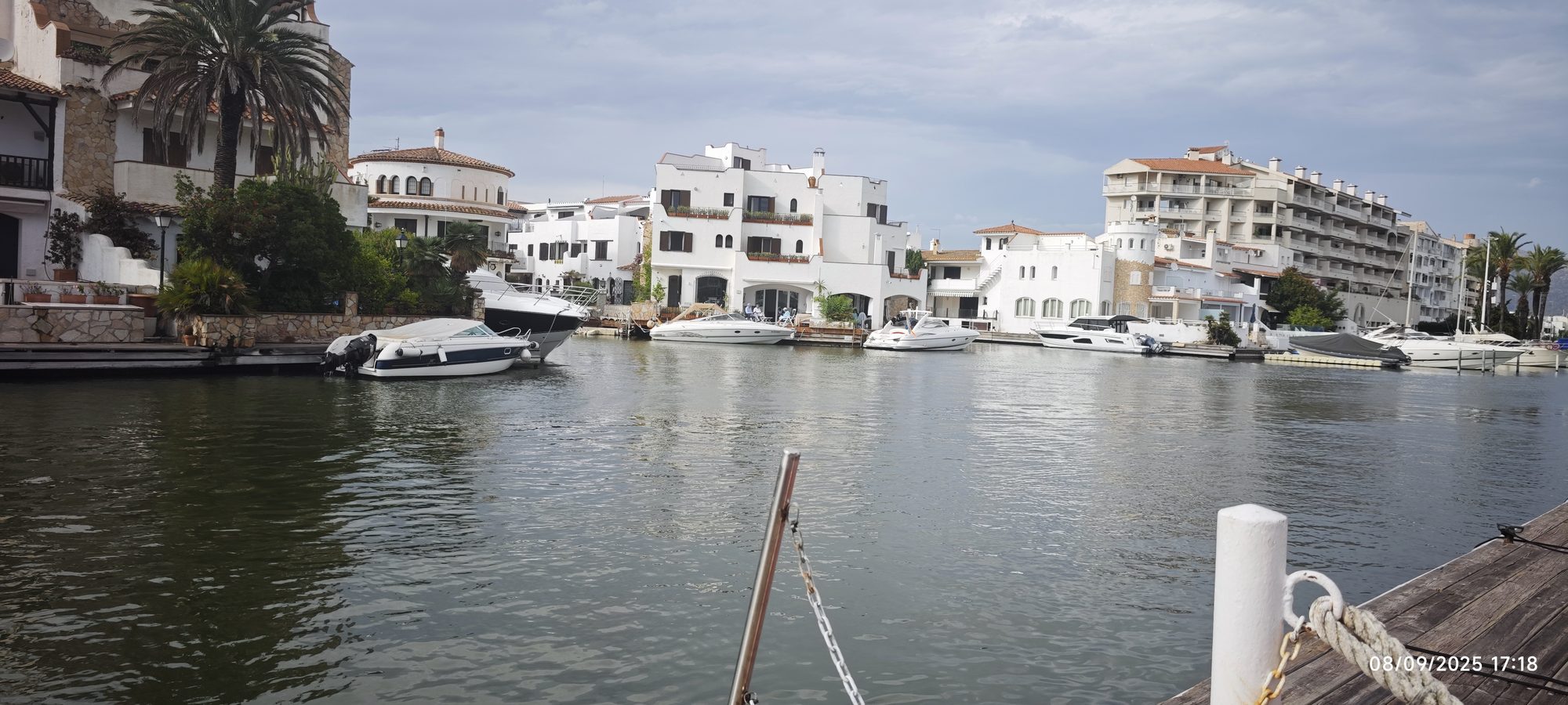 Canales navegables con barcos amarrados frente a casas blancas de estilo mediterráneo.