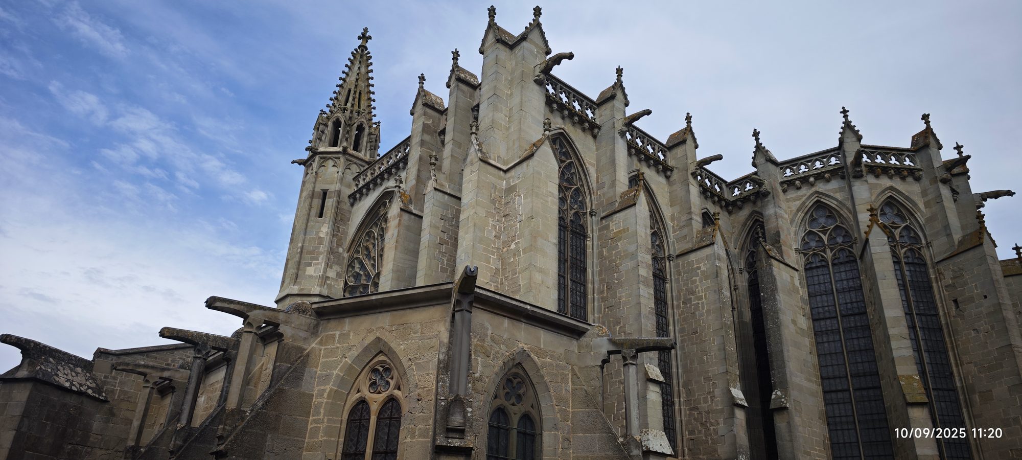Fachada exterior de la basílica gótica de Carcasona con gárgolas y ventanales con ojivas.