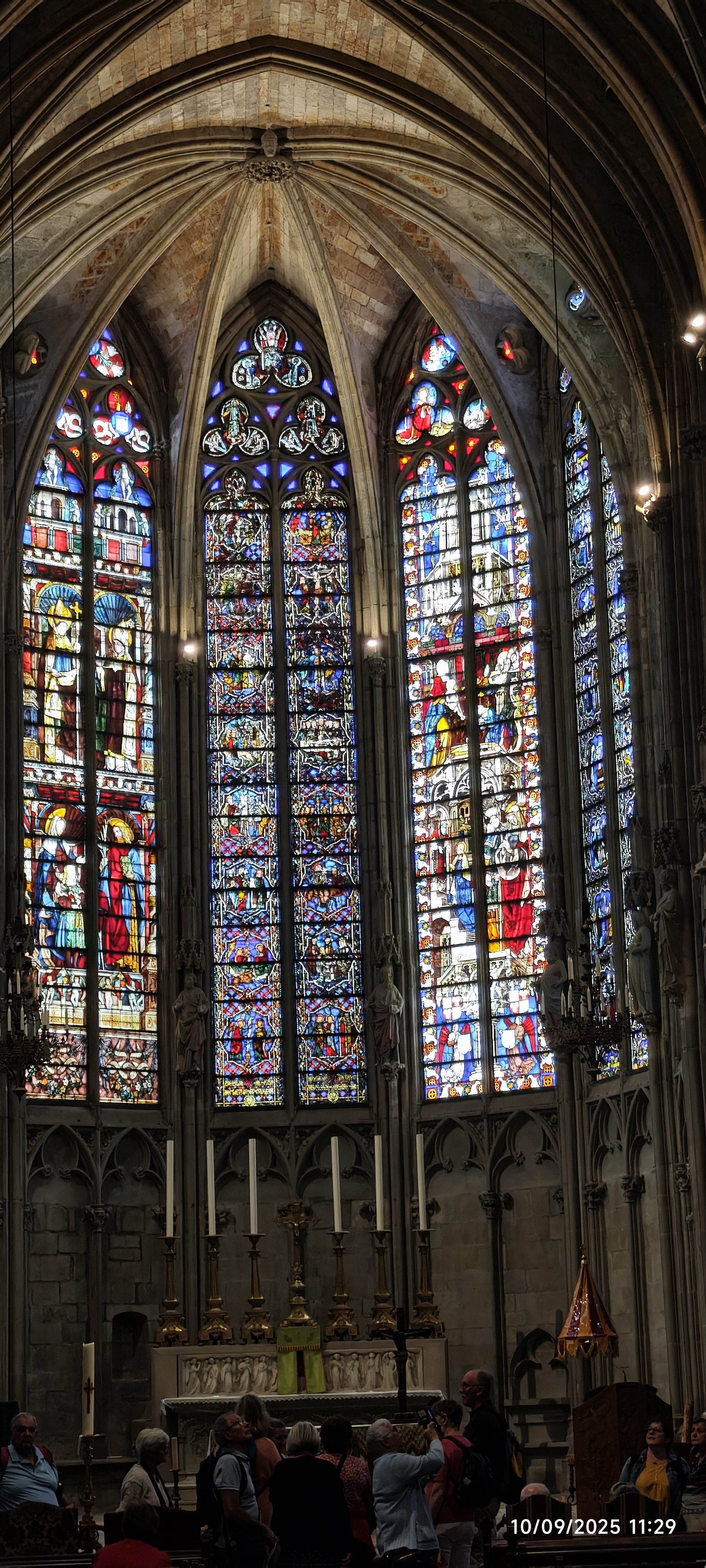 Imponentes vitrales góticos con luz colorida en el interior de la basílica de Carcasona.