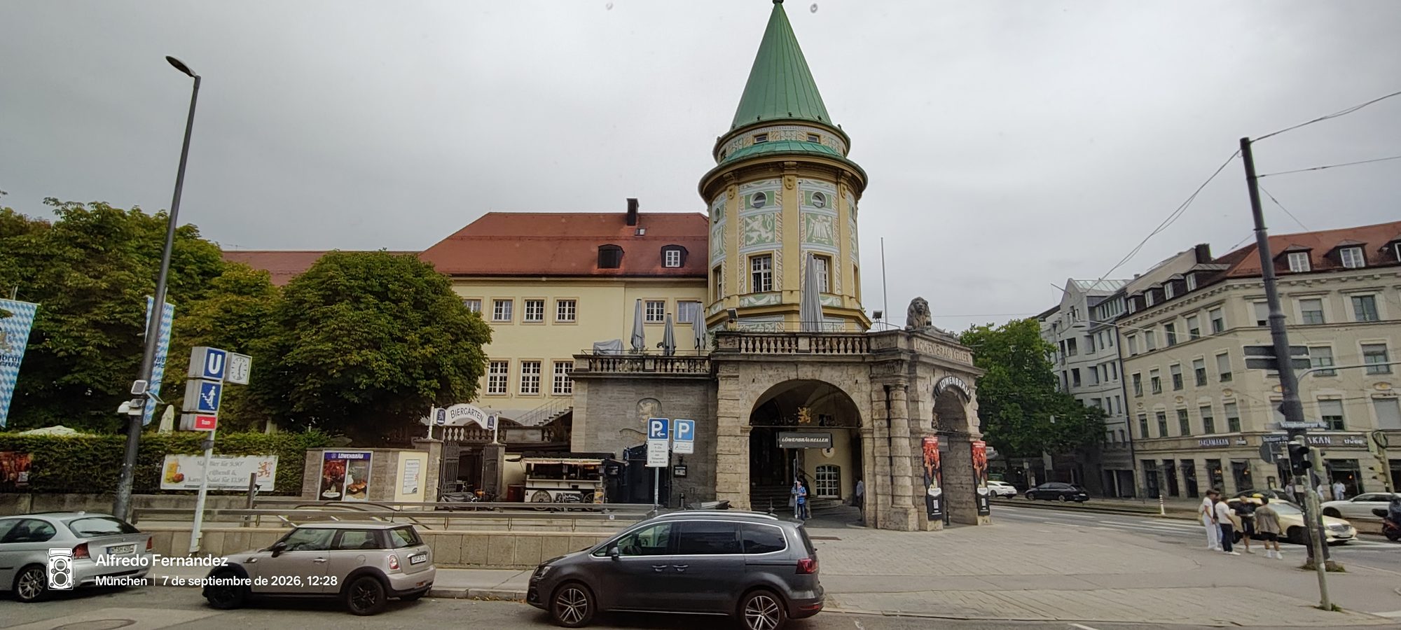 Edificio histórico de la cervecería Löwenbräukeller con torre cónica y terraza en Múnich.