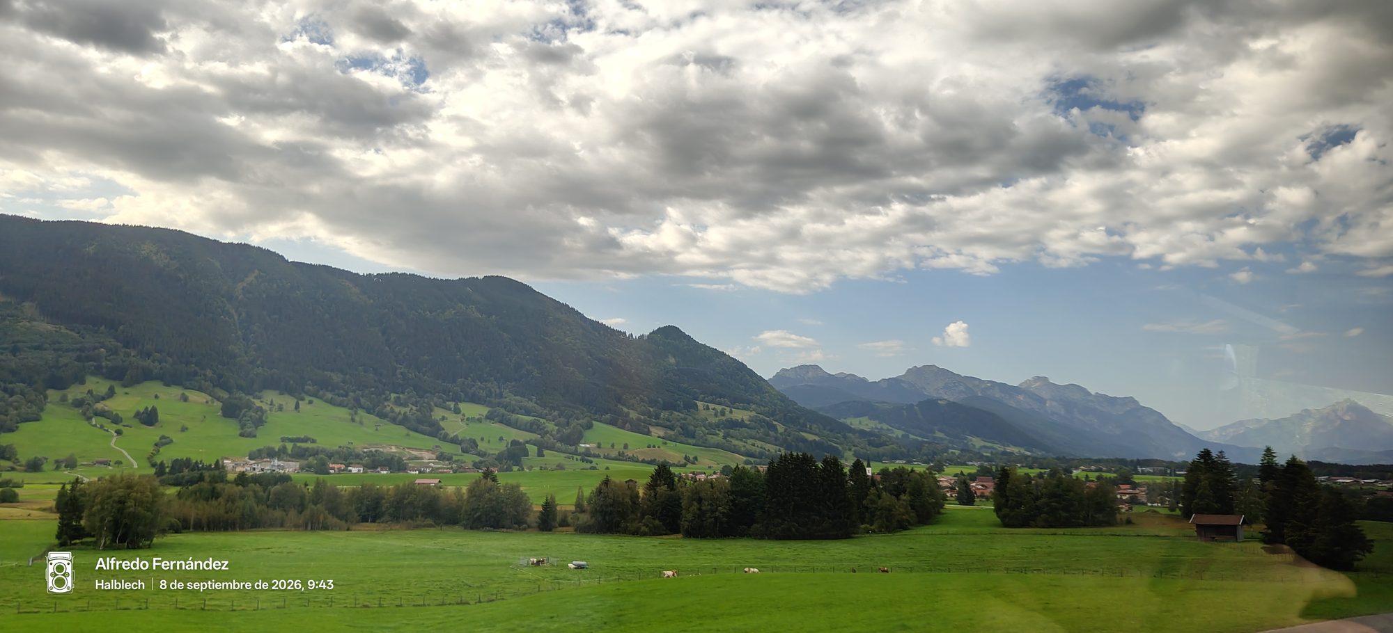 Prados verdes y montañas alpinas bajo un cielo parcialmente nublado en Halblech.