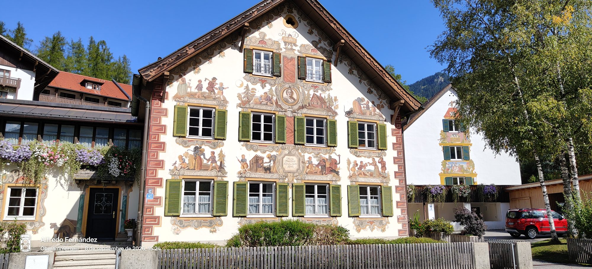 Casa bávara con pinturas murales de cuentos de hadas y contraventanas verdes.