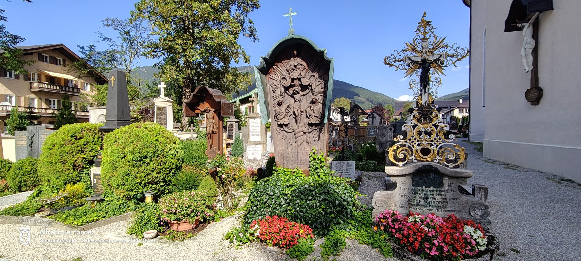 Cruces talladas y tumbas con flores en el histórico cementerio de Oberammergau.