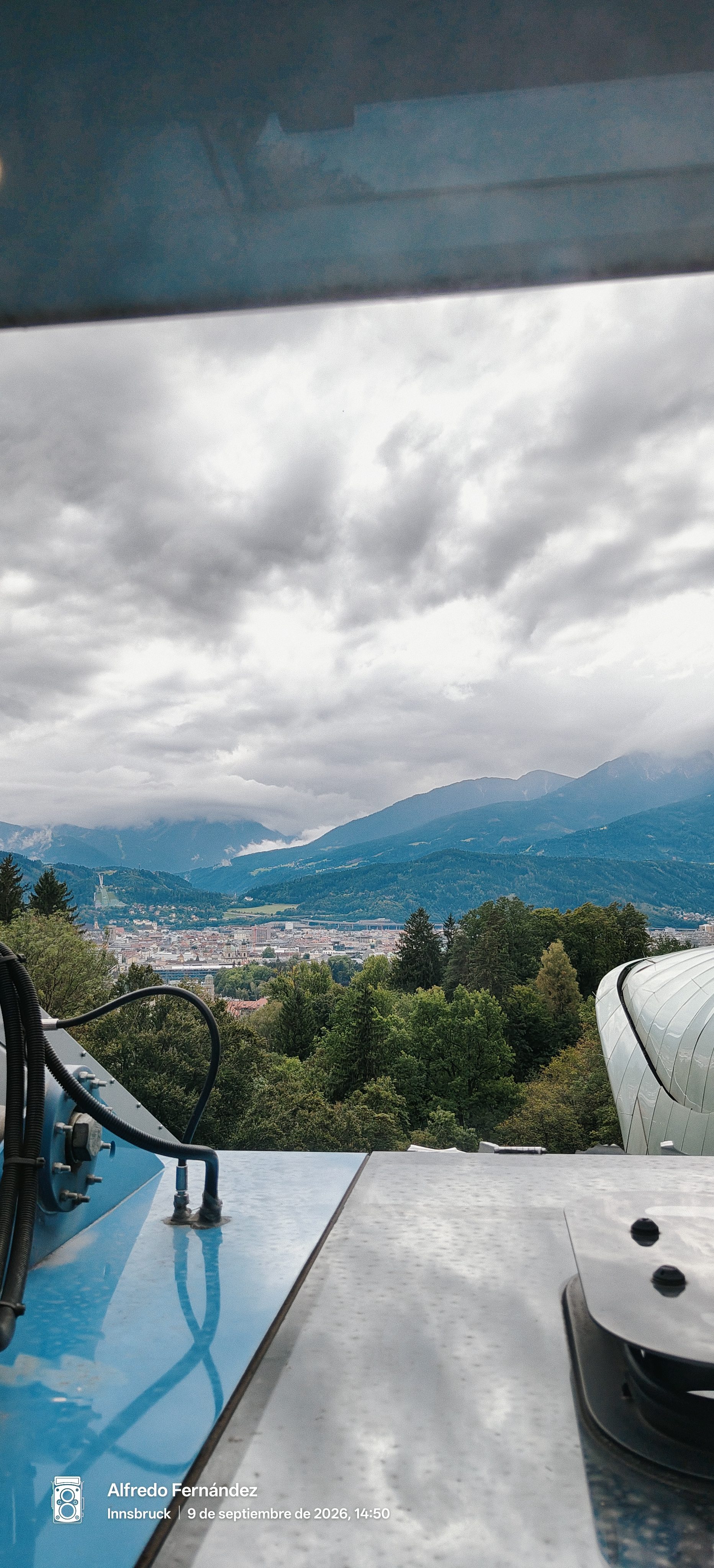 Vista panorámica de Innsbruck y los Alpes desde la estación del funicular bajo cielo nublado.