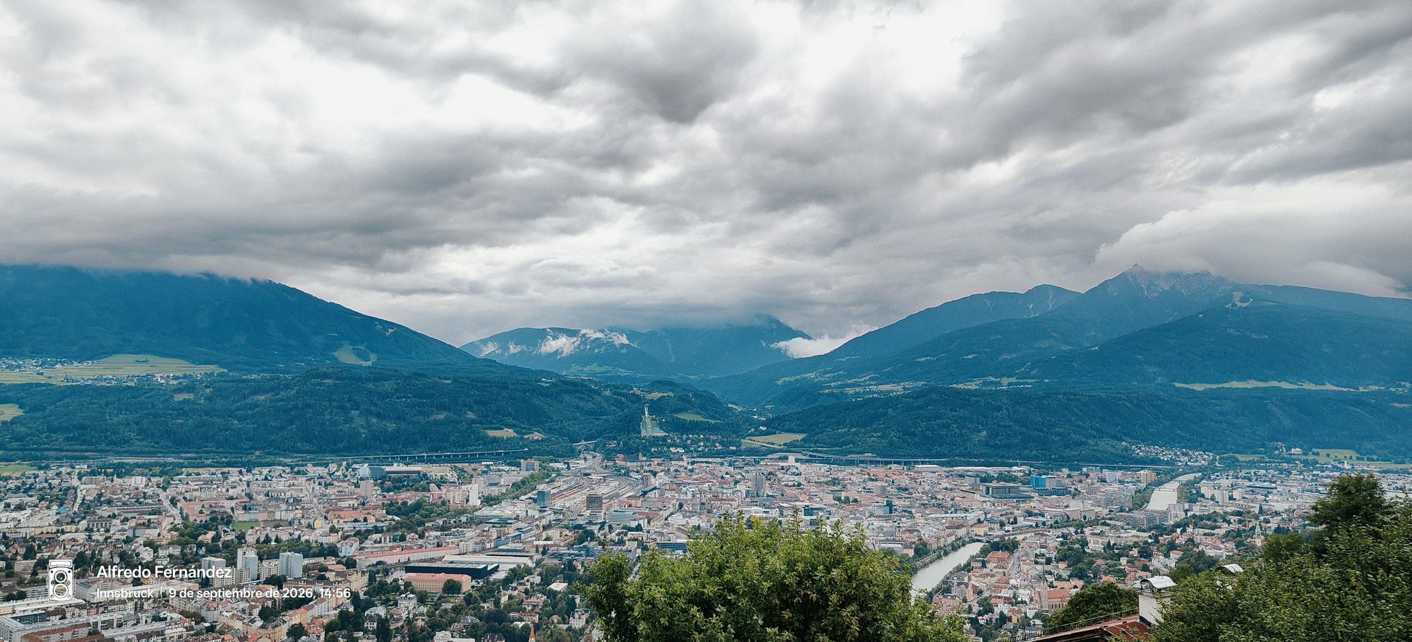 Vista panorámica de Innsbruck en el valle entre montañas alpinas bajo cielo nublado.