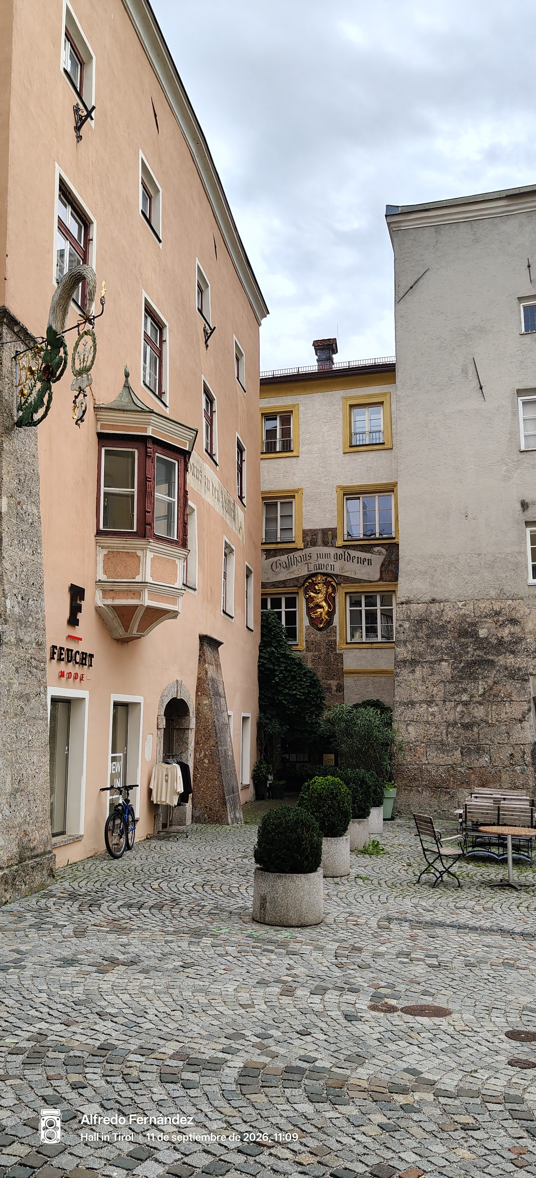 Fachadas históricas y suelo empedrado en una tranquila plaza de Hall in Tirol.