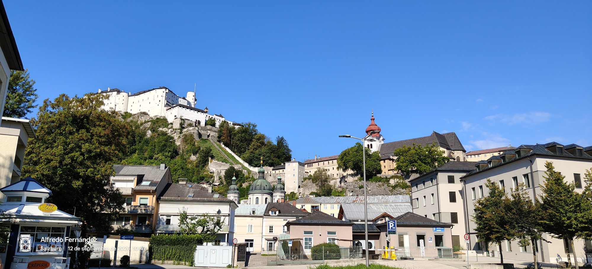 Fortaleza de Hohensalzburg sobre la colina y tejados urbanos bajo un cielo despejado.