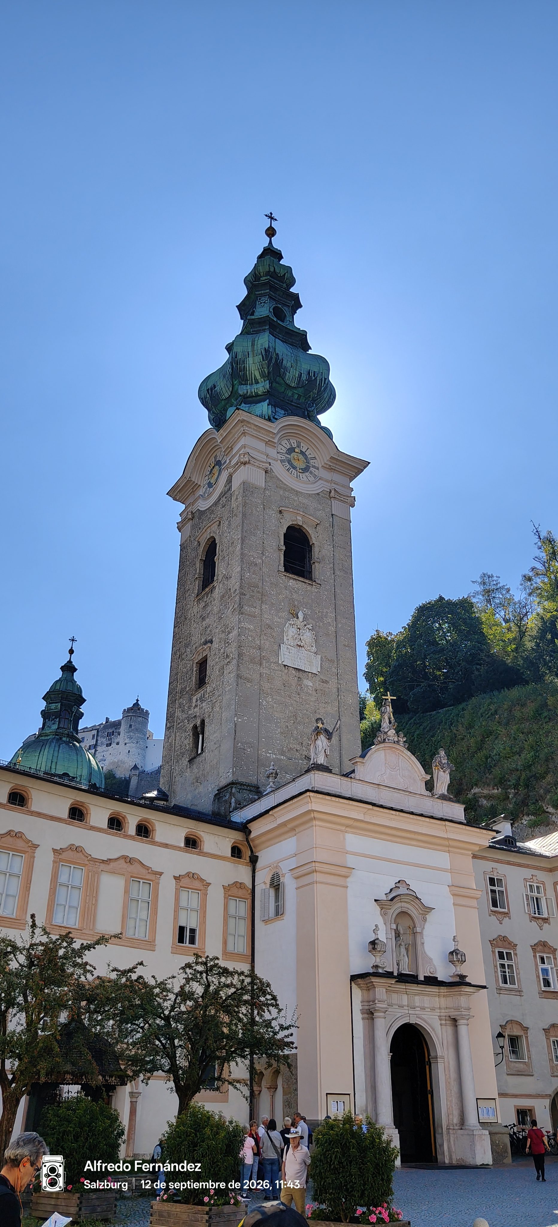 Campanario y fachada barroca de la abadía de San Pedro en Salzburgo bajo cielo despejado.