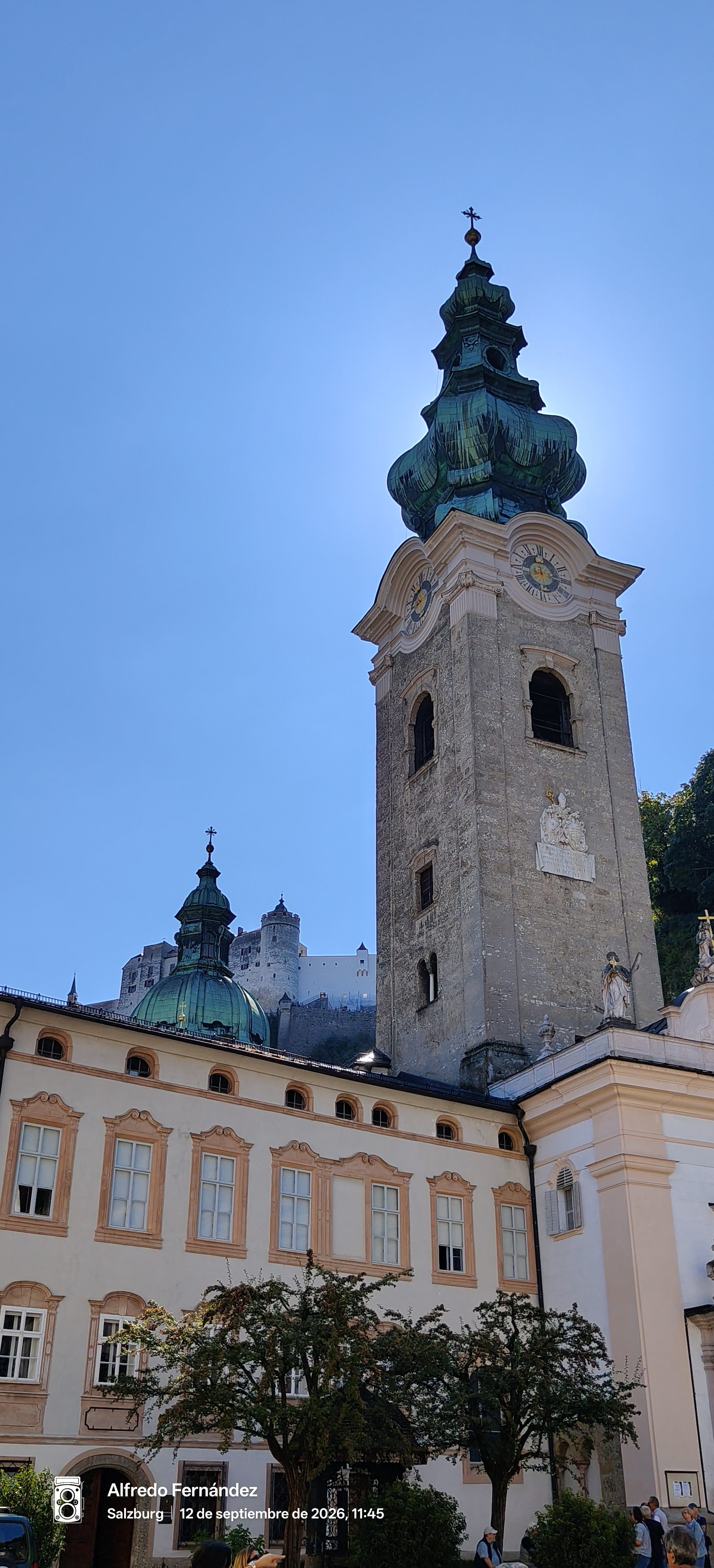Torre barroca de San Pedro y la fortaleza Hohensalzburg bajo el cielo azul.