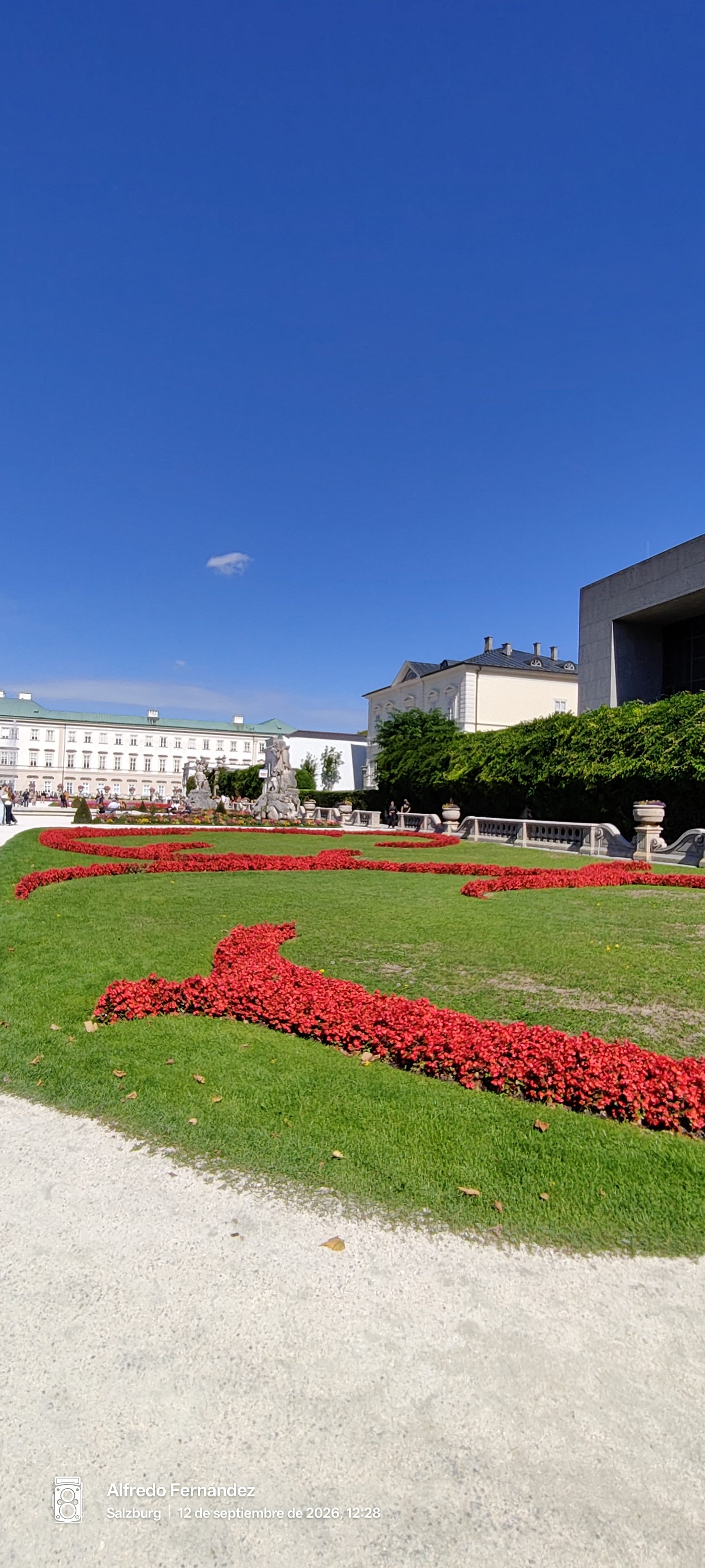 Parterres de flores rojas y césped en los jardines del Palacio de Mirabell.