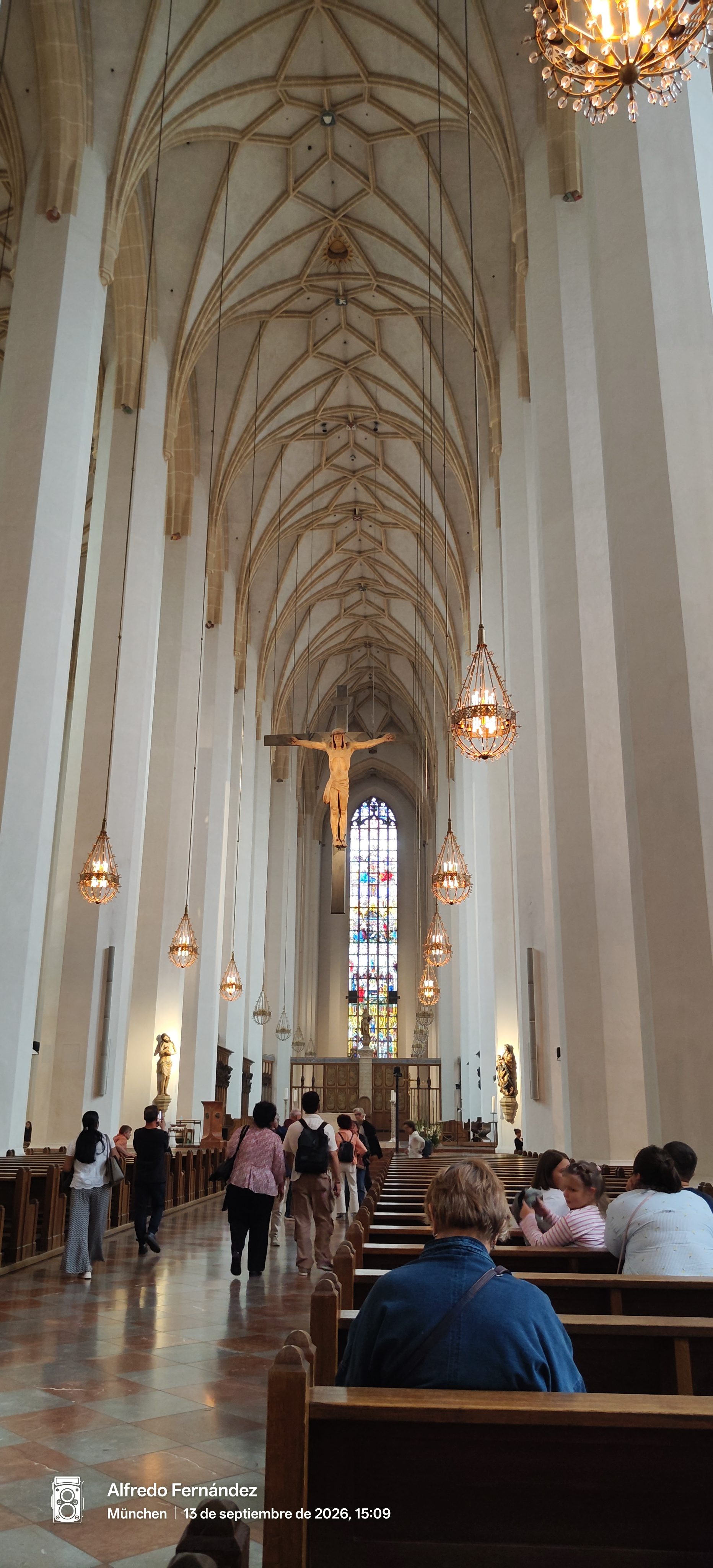 Interior de la catedral de Múnich con altos techos abovedados y lámparas colgantes.