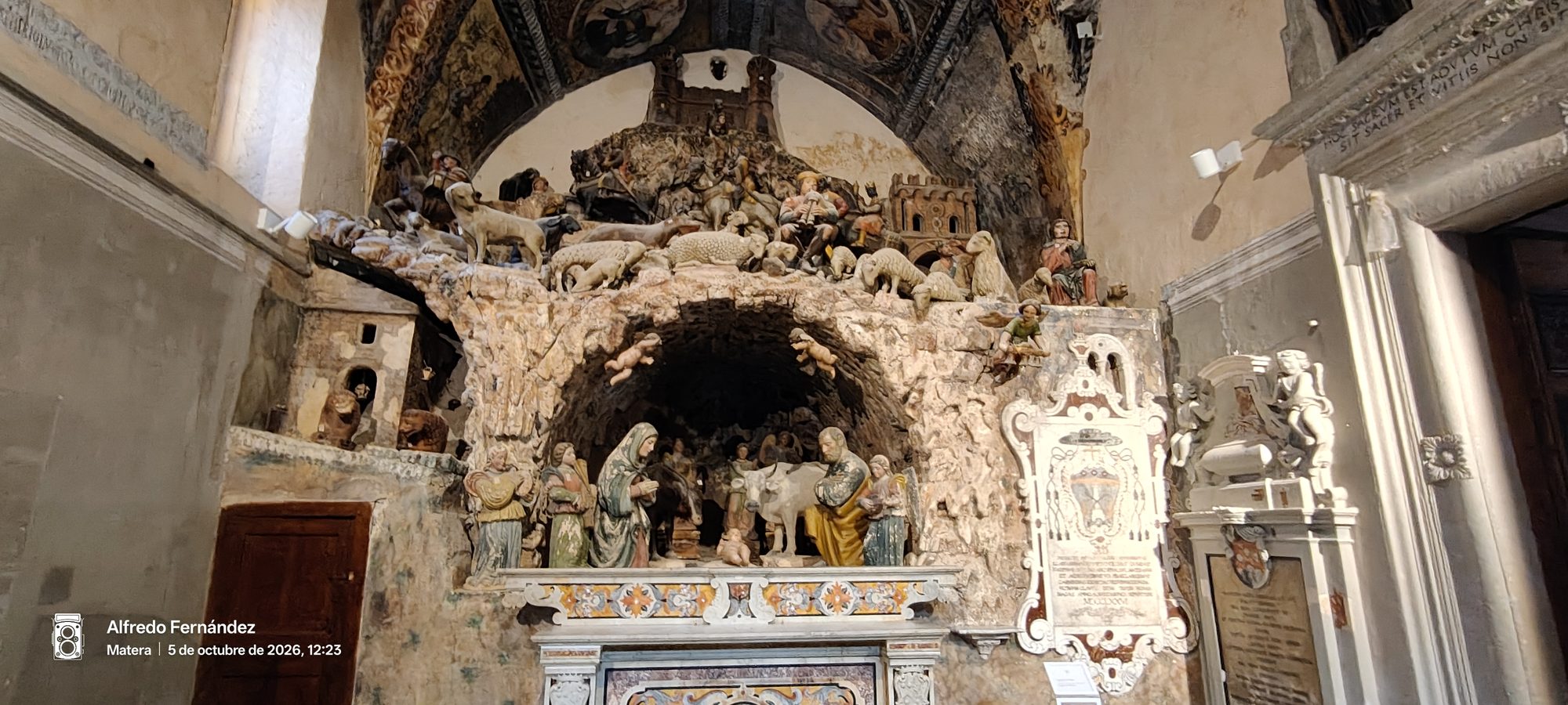 Escultura monumental de un belén en piedra caliza dentro de una iglesia antigua.