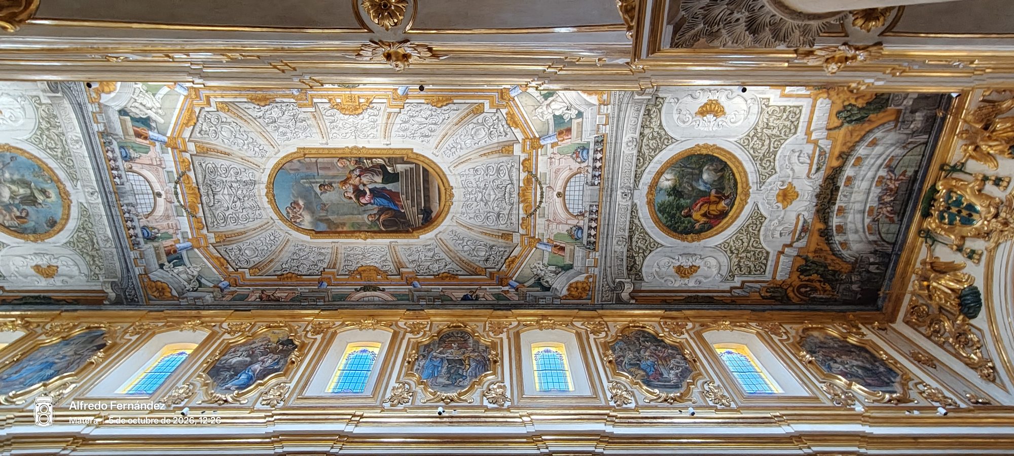 Techo dorado y frescos religiosos barrocos decorando el interior de una iglesia en Matera.