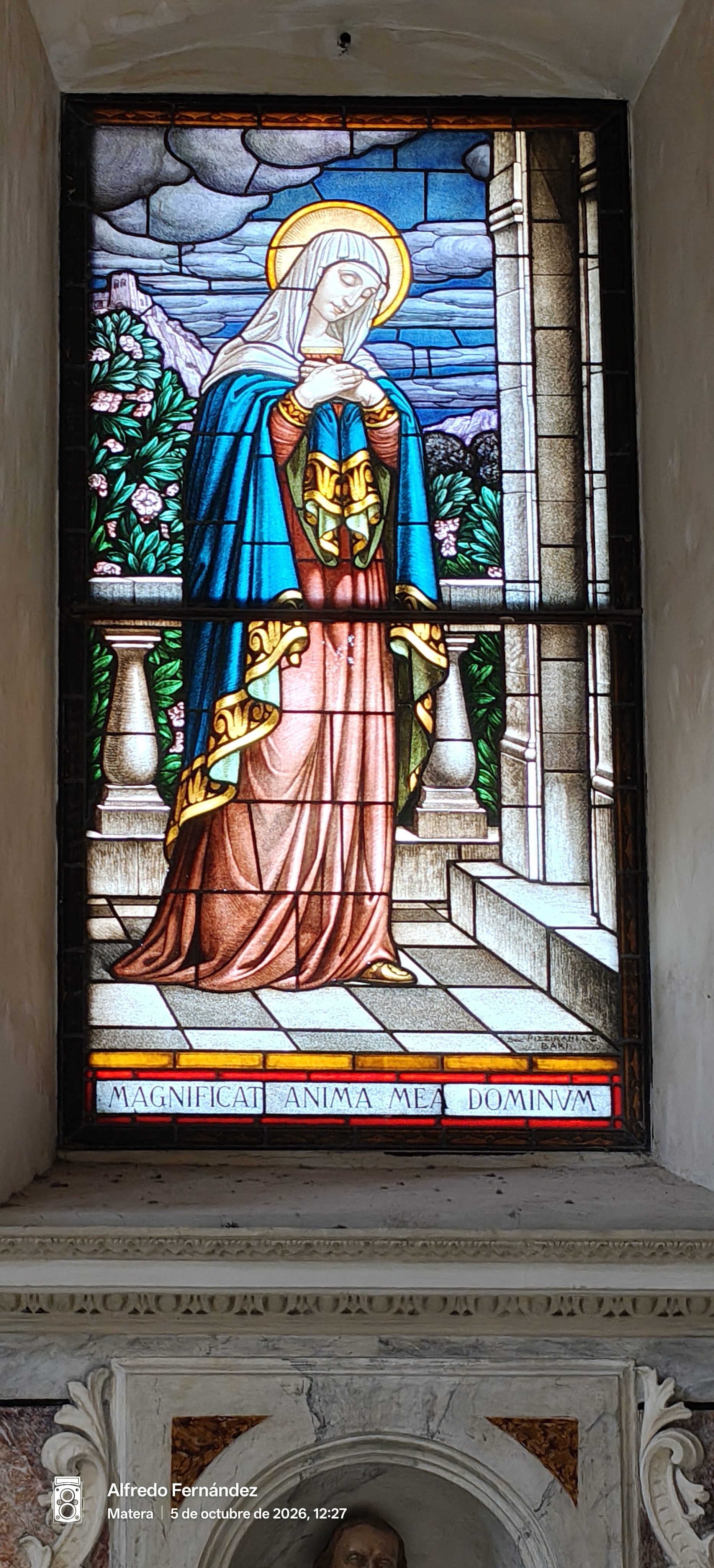 Vidriera religiosa que representa a la Virgen María con la inscripción en latín Magnificat