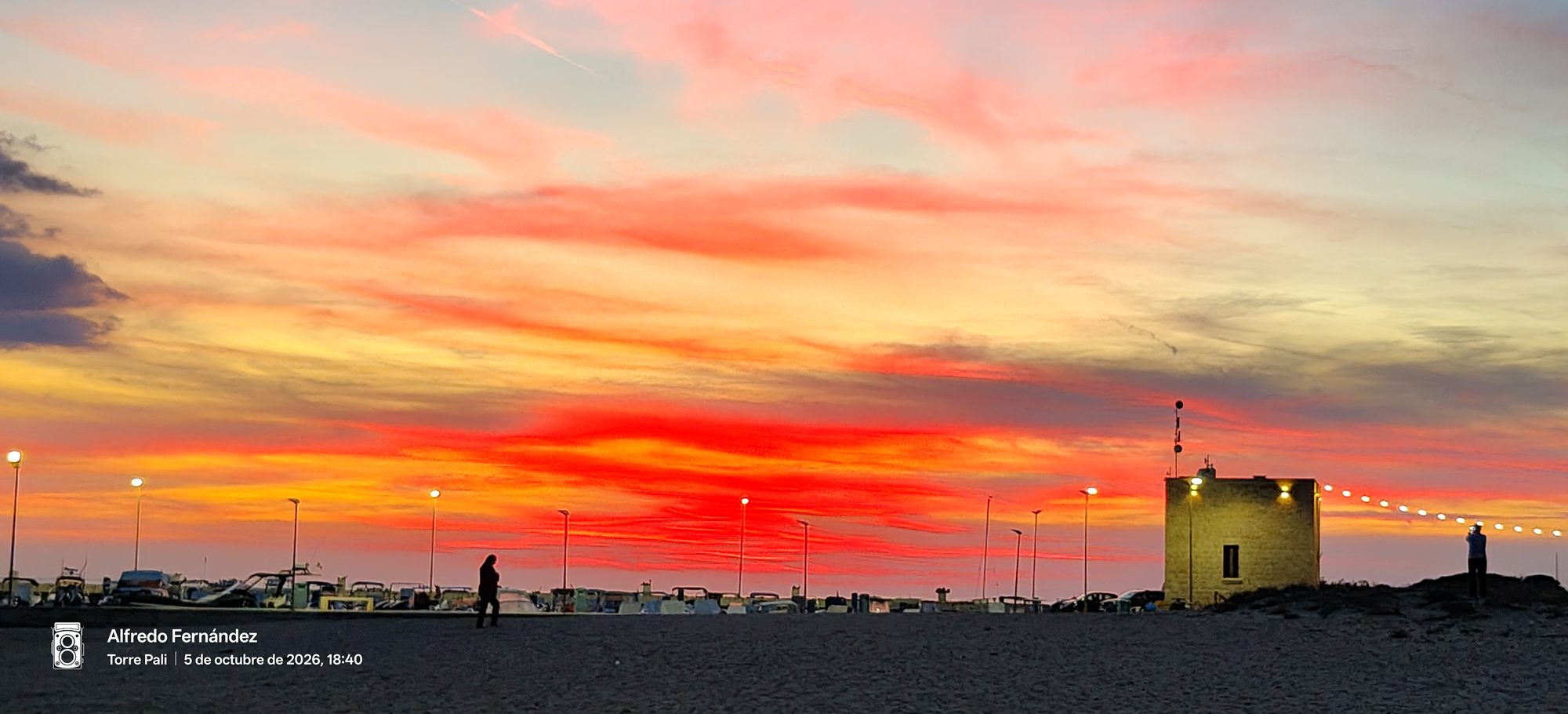 Cielo encendido al atardecer en tonos rojizos y naranjas sobre la costa de Torre Pali.