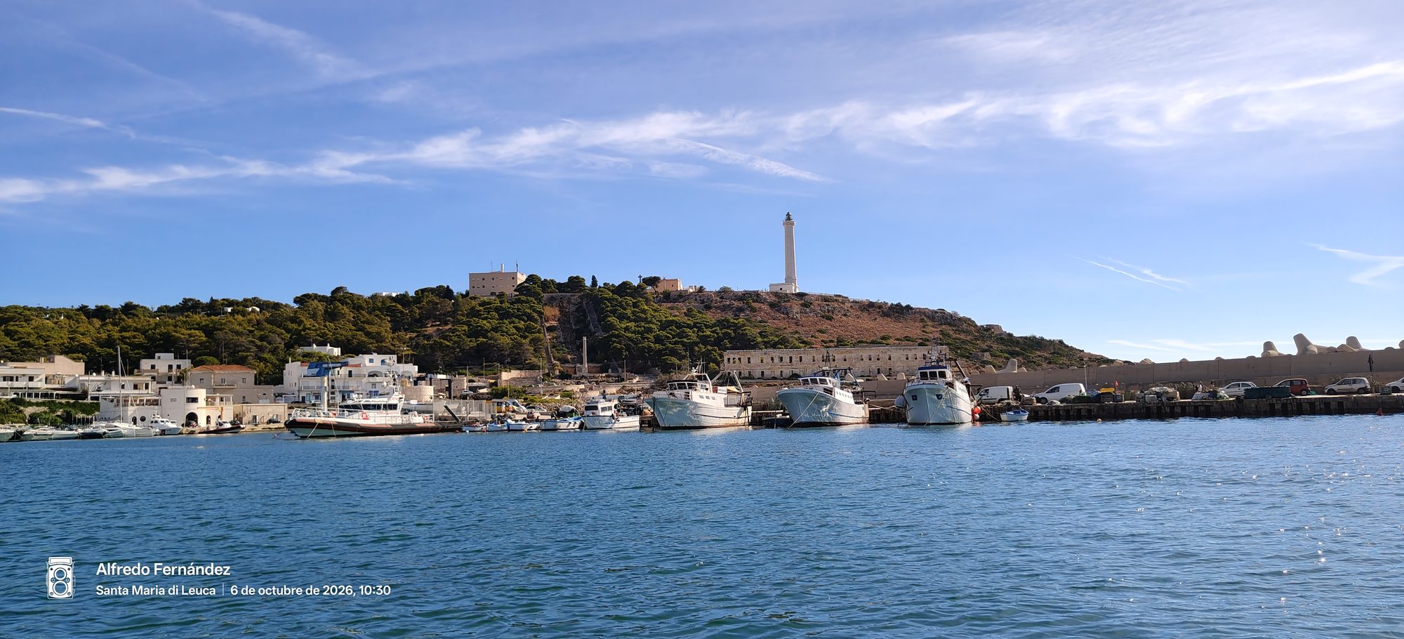 Barcos amarrados en el puerto costero bajo el faro de Santa Maria di Leuca.