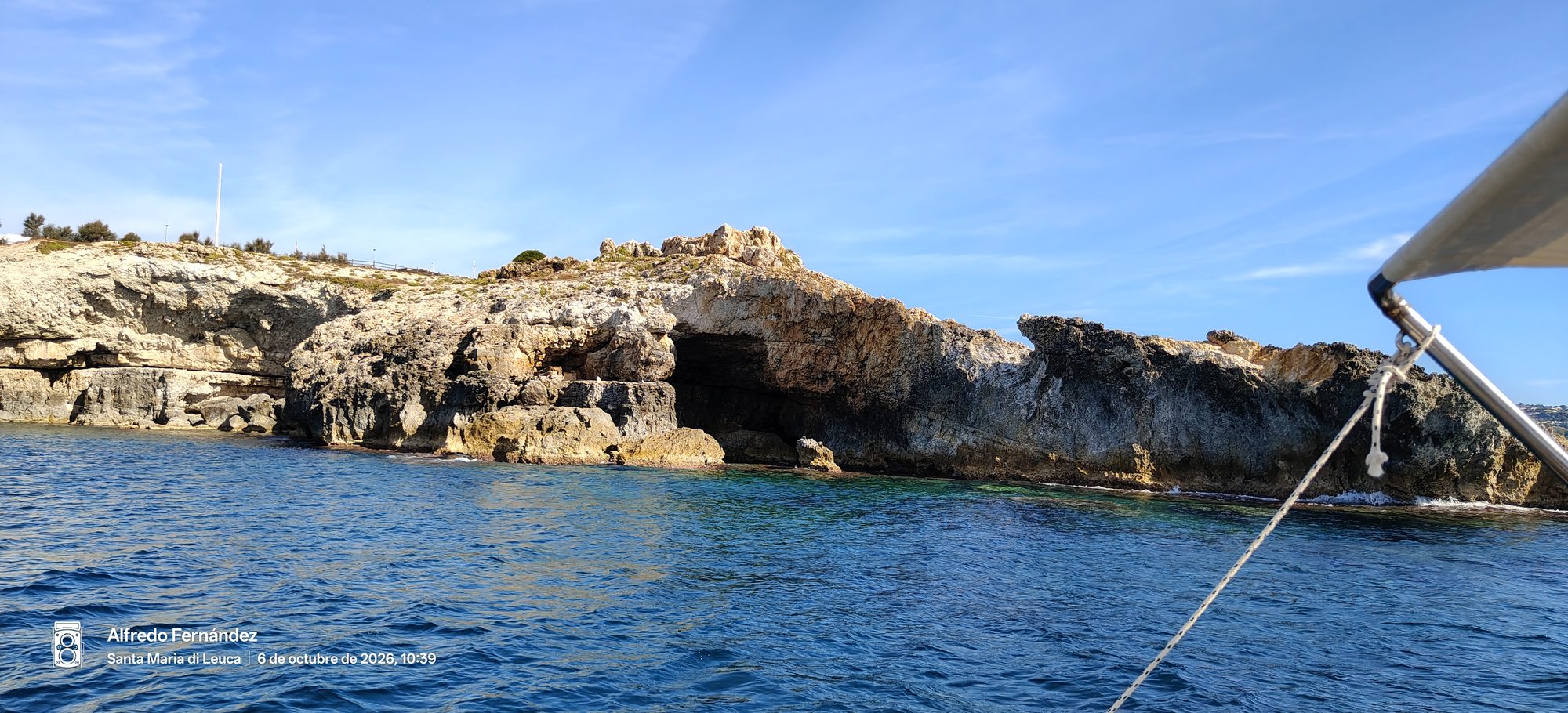 Acantilados rocosos y cuevas marinas frente al mar azul vistas desde una embarcación.