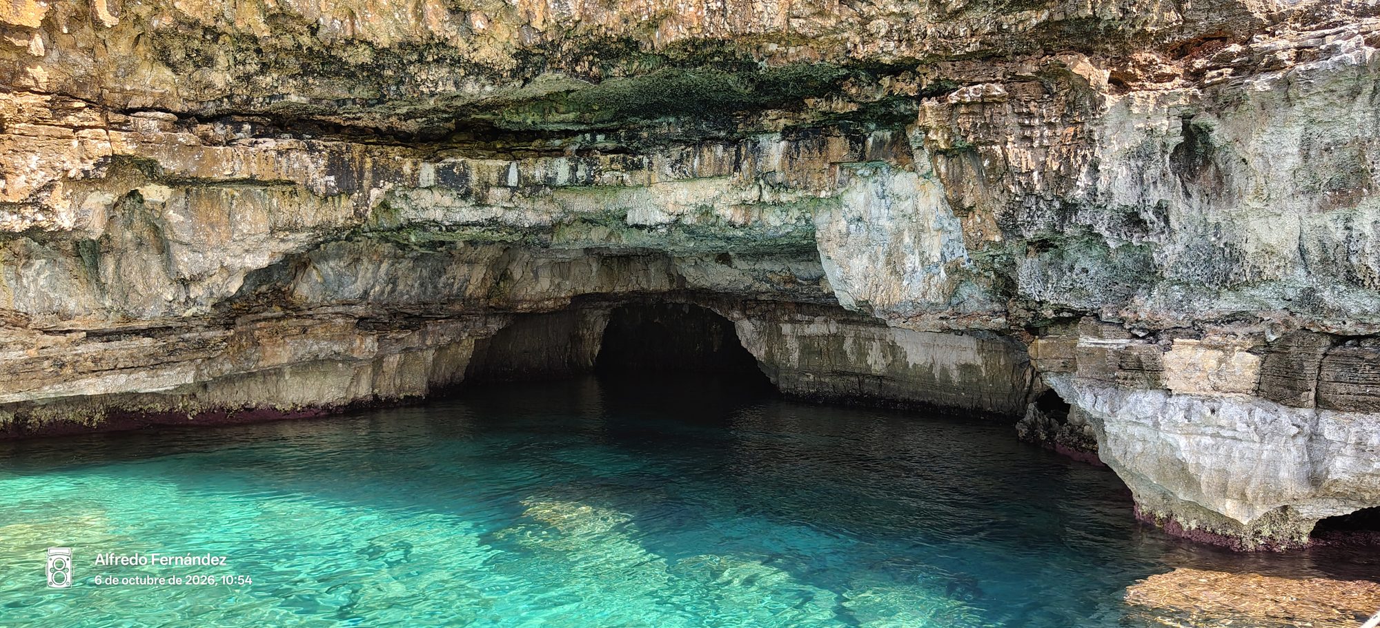 Cueva marina natural de roca caliza sobre aguas cristalinas de intenso color turquesa.