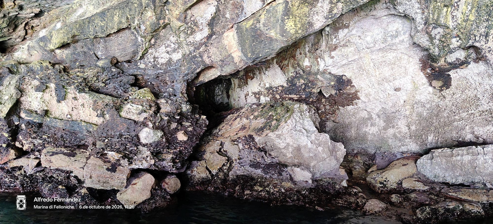 Formación rocosa y cavidad marina en un acantilado junto a la orilla del mar.