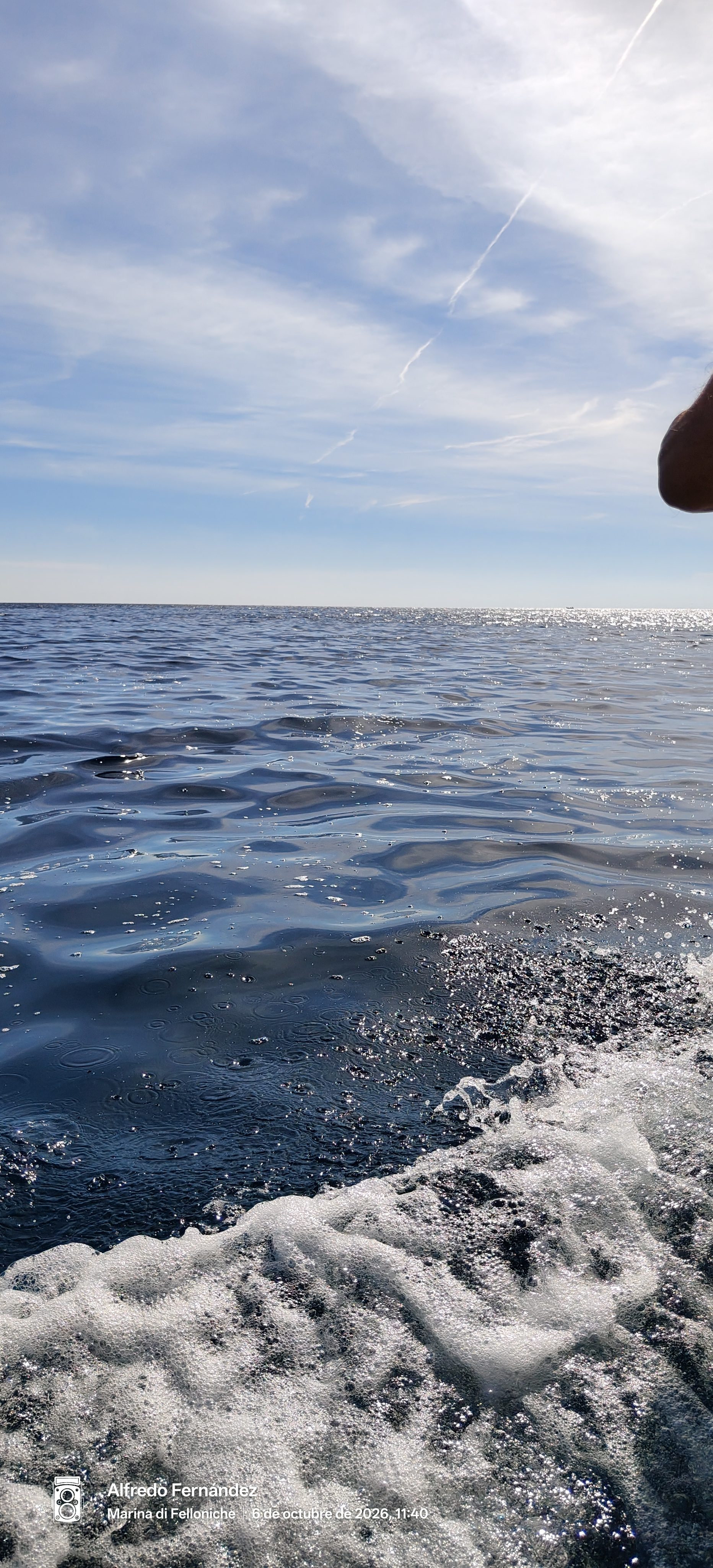 Aguas azules del mar abierto y espuma del oleaje bajo un cielo despejado.