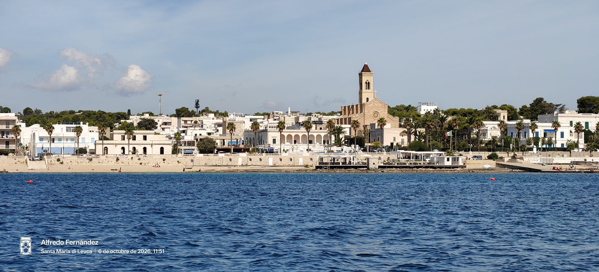 Costa y edificios de Santa Maria di Leuca con su iglesia frente al mar azul.