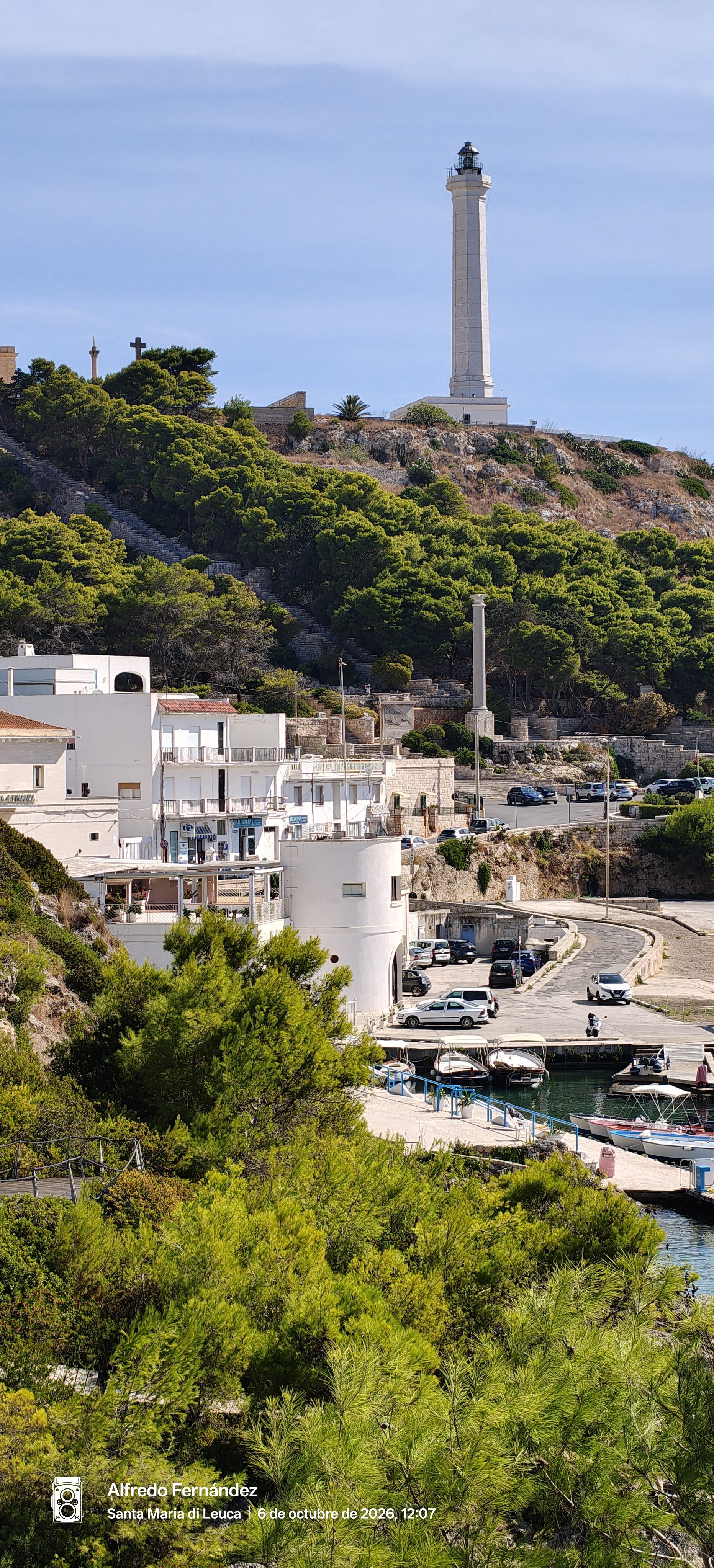 Faro blanco en una colina verde sobre el puerto de Santa Maria di Leuca.