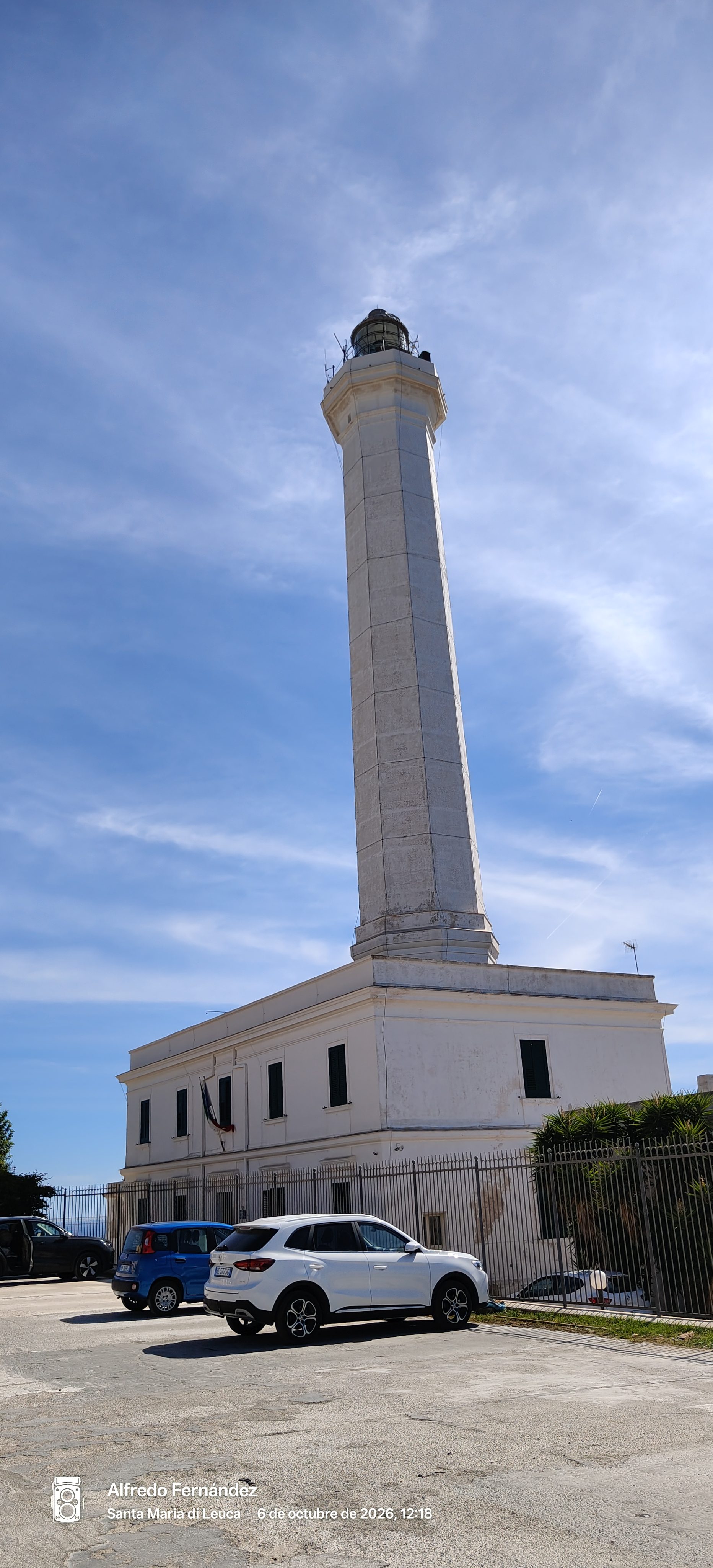 Alto faro blanco de Santa Maria di Leuca bajo un cielo azul despejado.