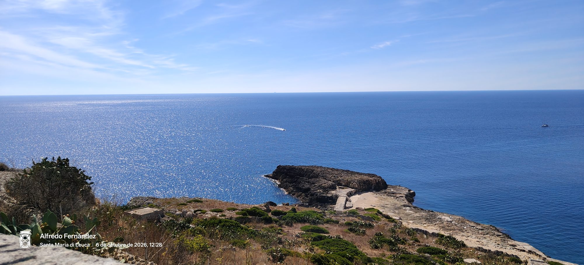 Acantilados y costa rocosa frente a un inmenso mar azul bajo cielo despejado.