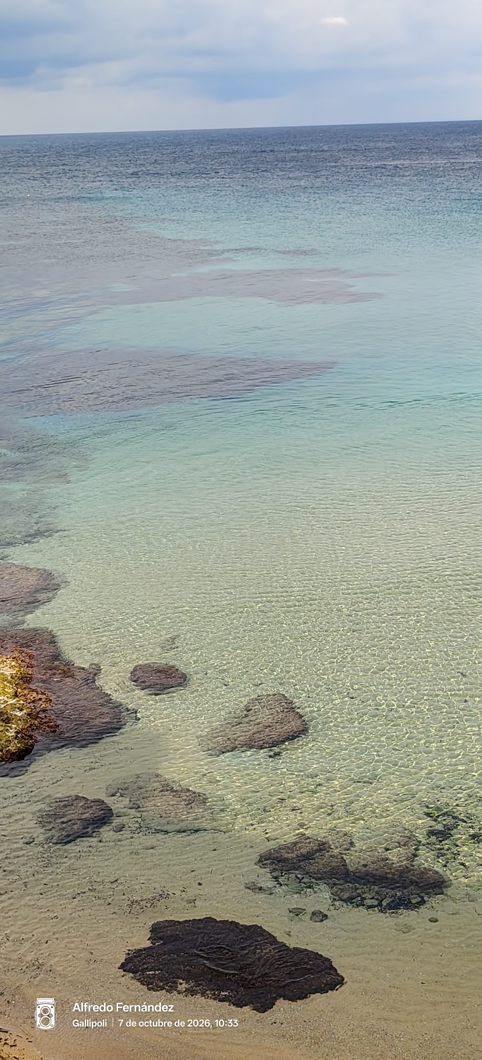 Aguas cristalinas y turquesas sobre fondo rocoso y arena en la costa de Gallipoli.