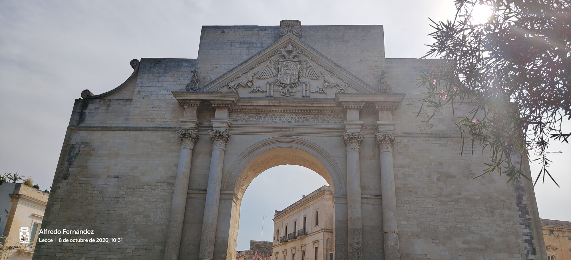 Arco monumental de piedra de Porta Napoli bajo el cielo soleado de Lecce.