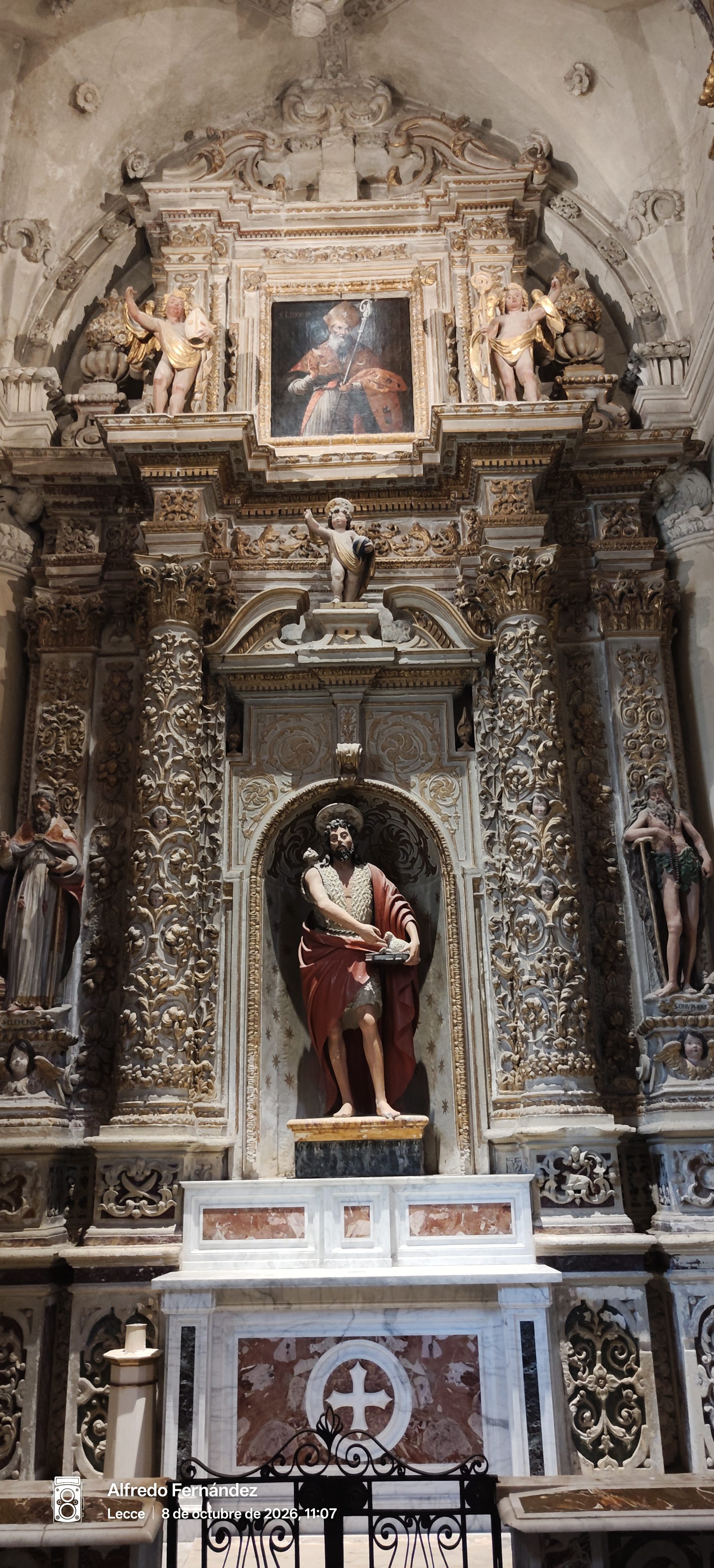 Altar barroco profusamente decorado con esculturas religiosas y columnas talladas en una iglesia