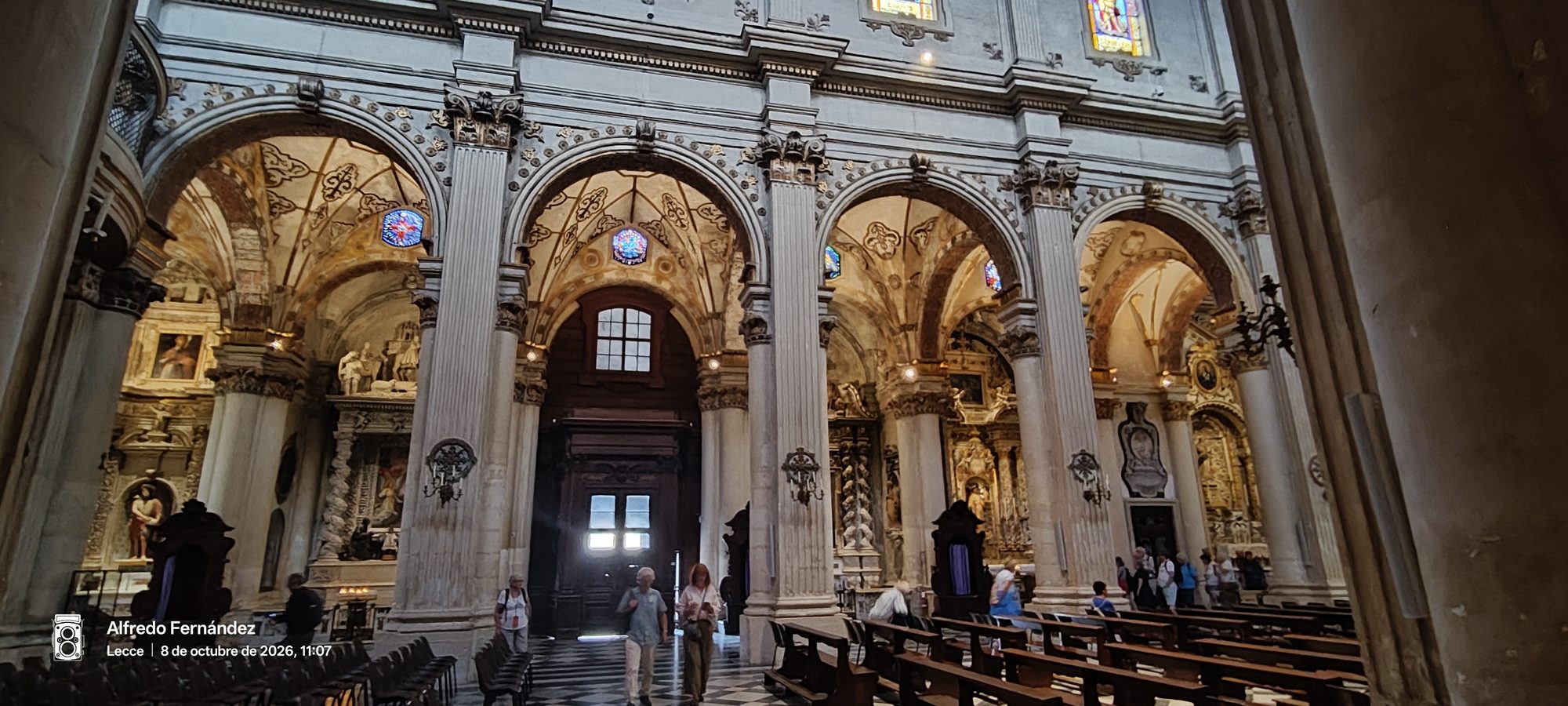 Interior de la catedral de Lecce con imponentes arcos de piedra tallada y bóvedas decoradas.
