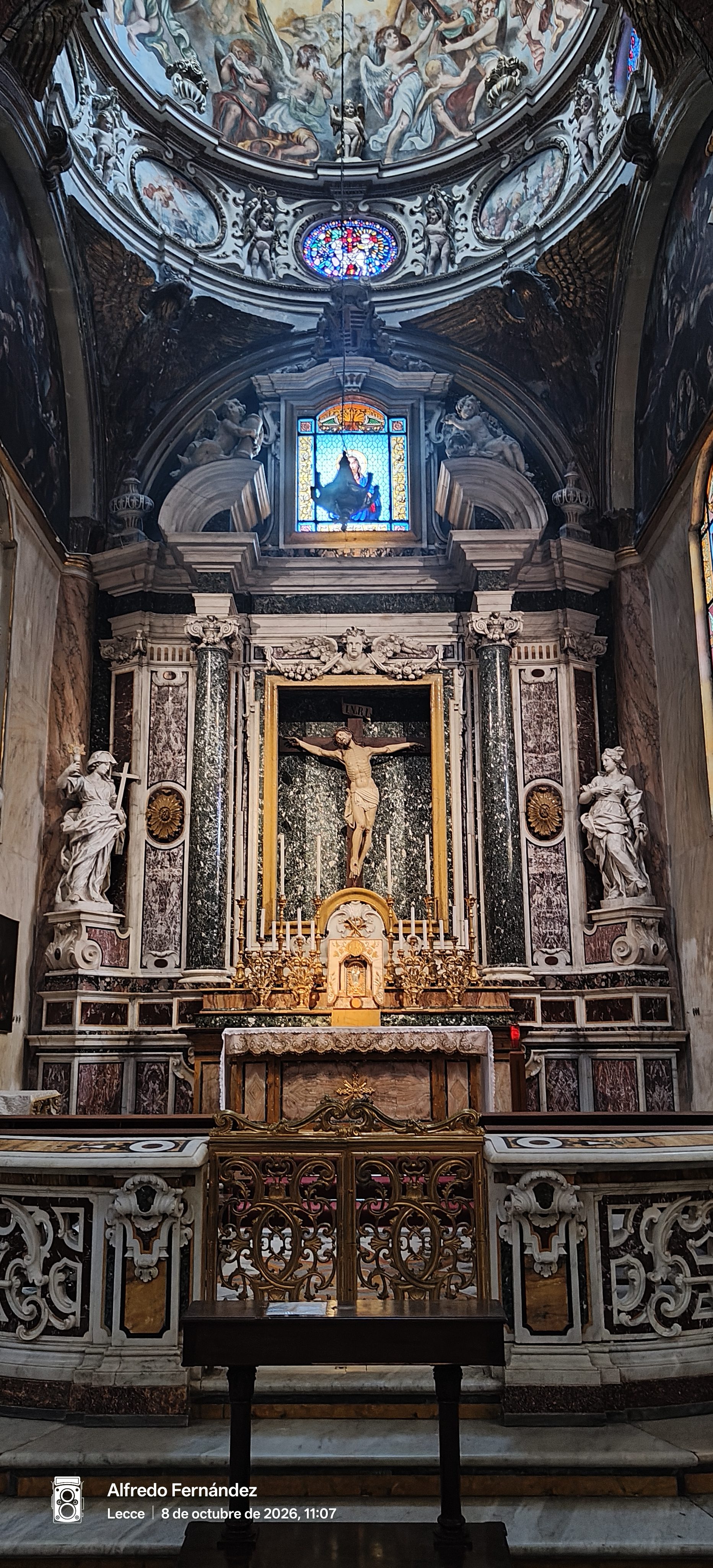 Altar barroco de mármol con crucifijo, esculturas y cúpula pintada con frescos.