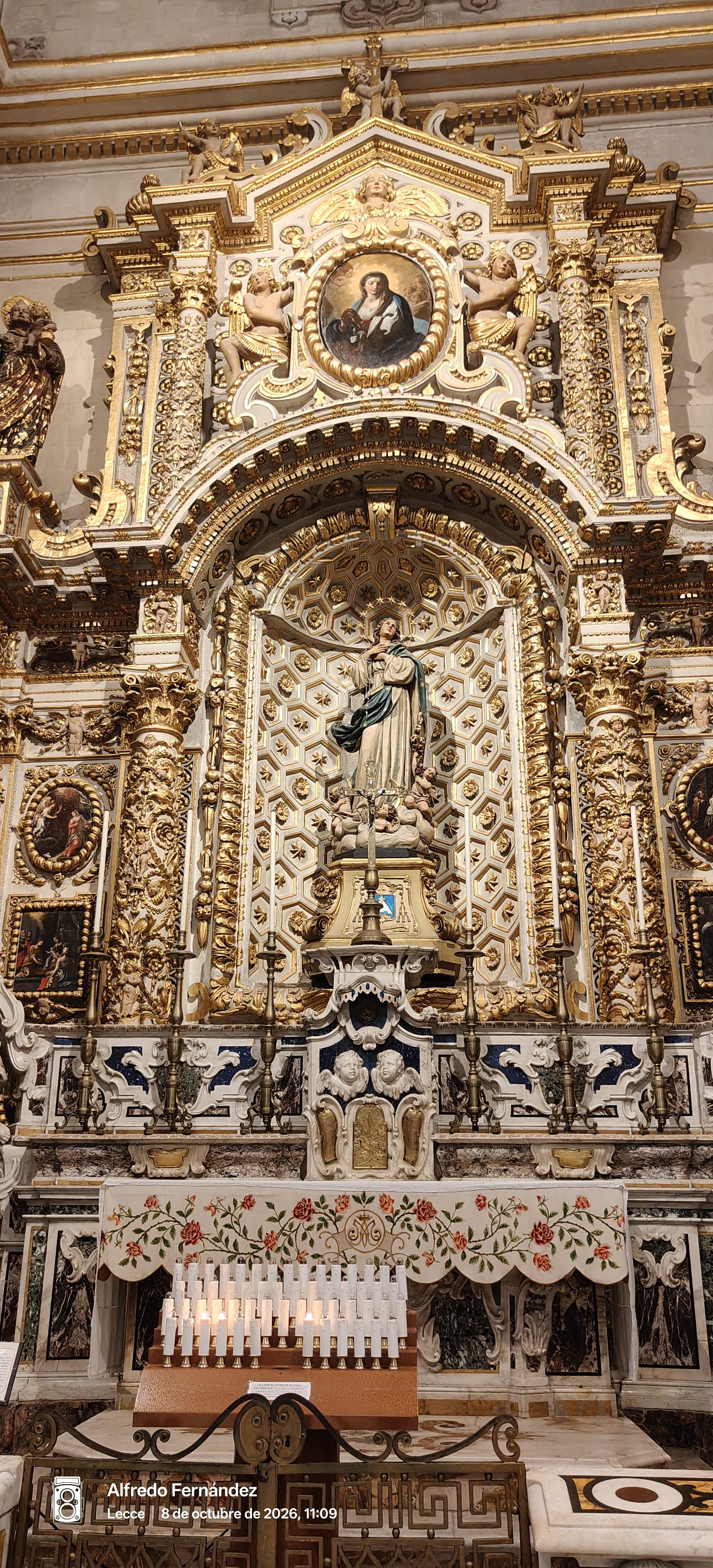 Retablo barroco dorado con estatua de la Virgen María y velas en Lecce.
