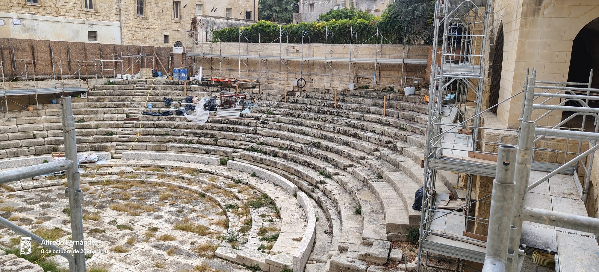 Gradas de piedra del antiguo teatro romano entre andamios de restauración en Lecce.