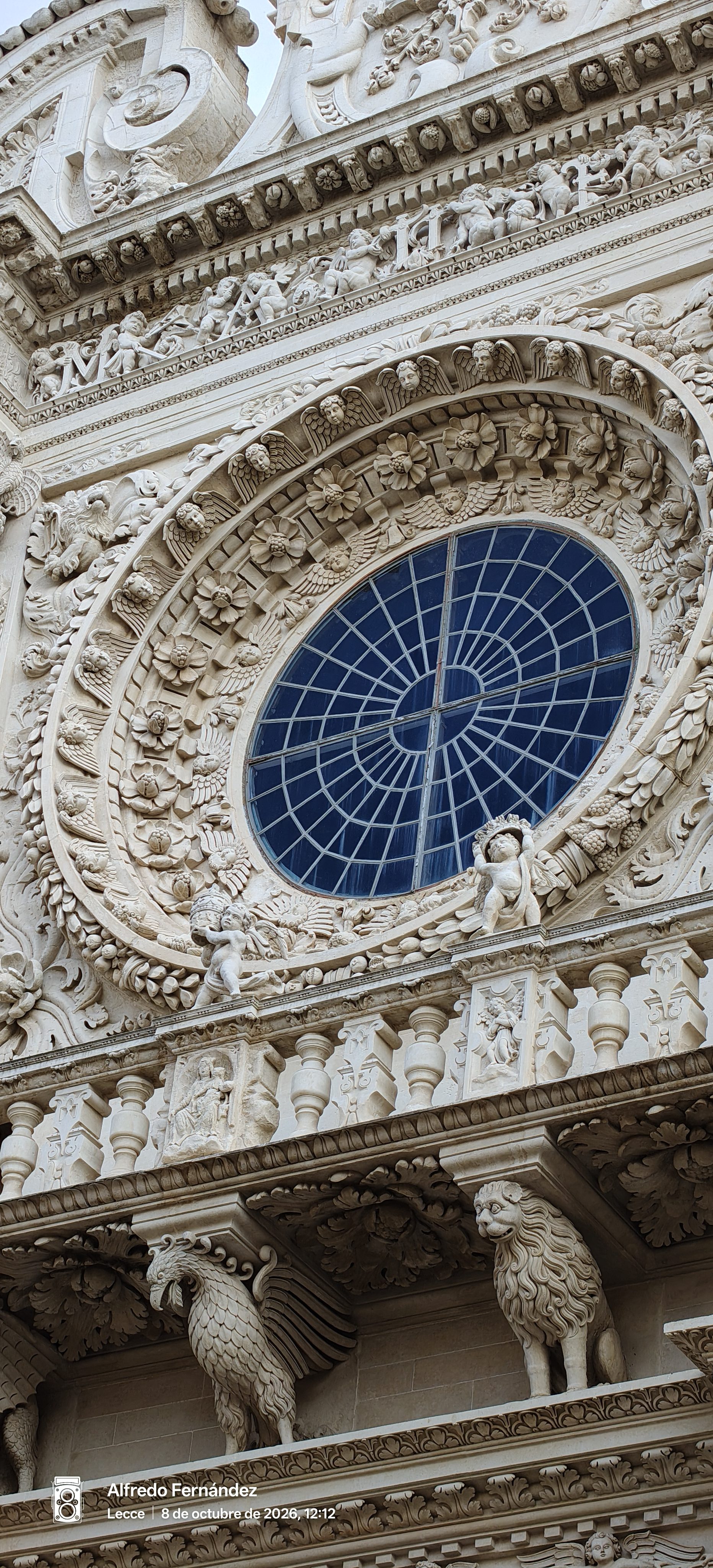 Detalle del rosetón barroco esculpido en piedra con ángeles y relieves en Lecce.