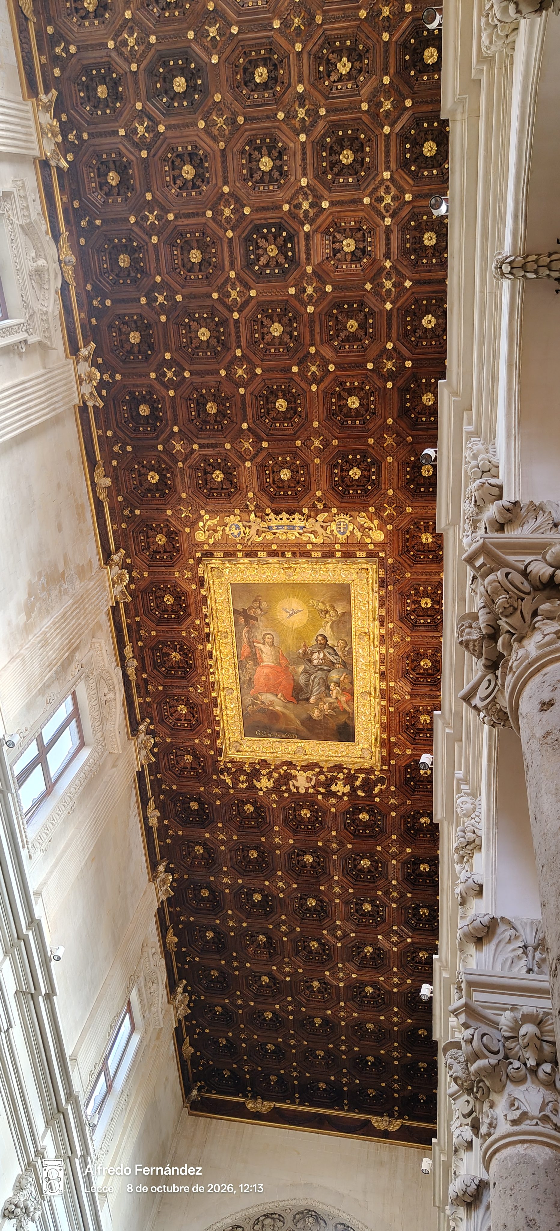 Techo artesonado de madera tallada con dorados y pintura religiosa en una iglesia barroca.