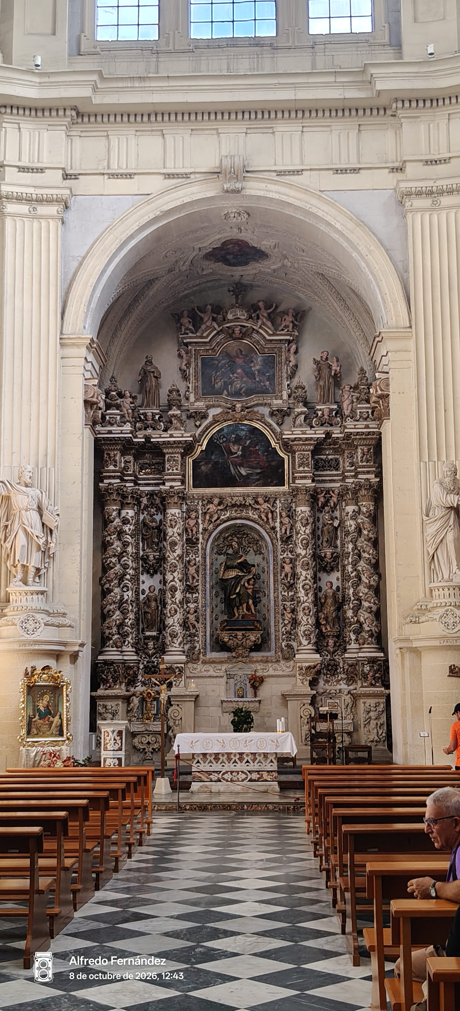 Altar barroco con relieves tallados y pinturas religiosas en una iglesia de Lecce.