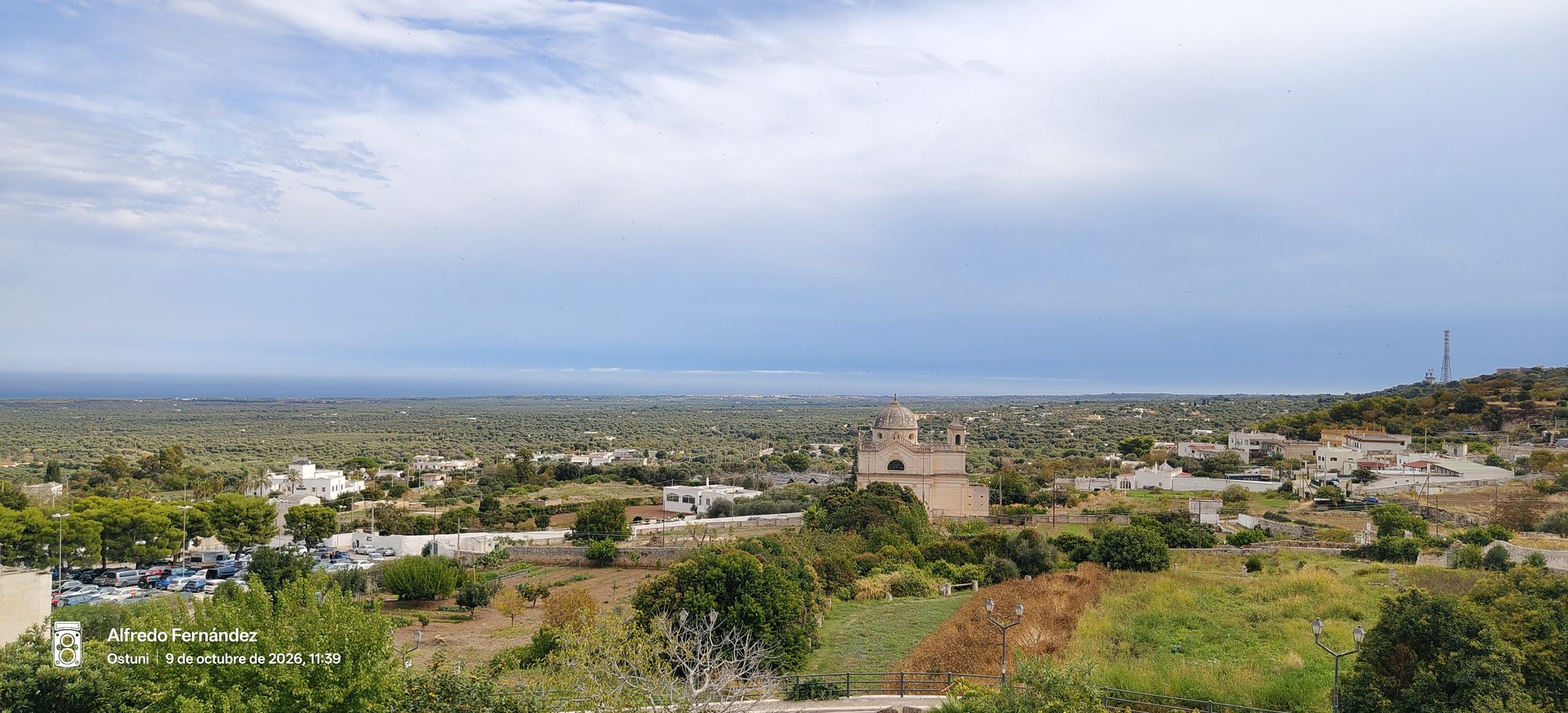 Llanura de olivos y una iglesia con cúpula frente al mar en Ostuni.