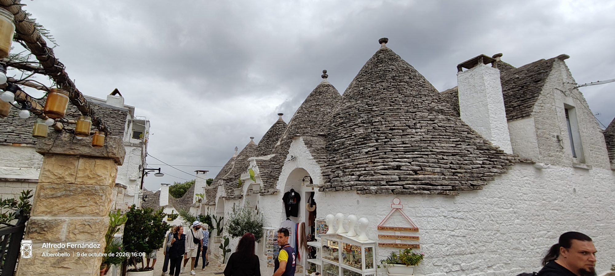 Trulli tradicionales de piedra blanca con techos cónicos en una calle de Alberobello.