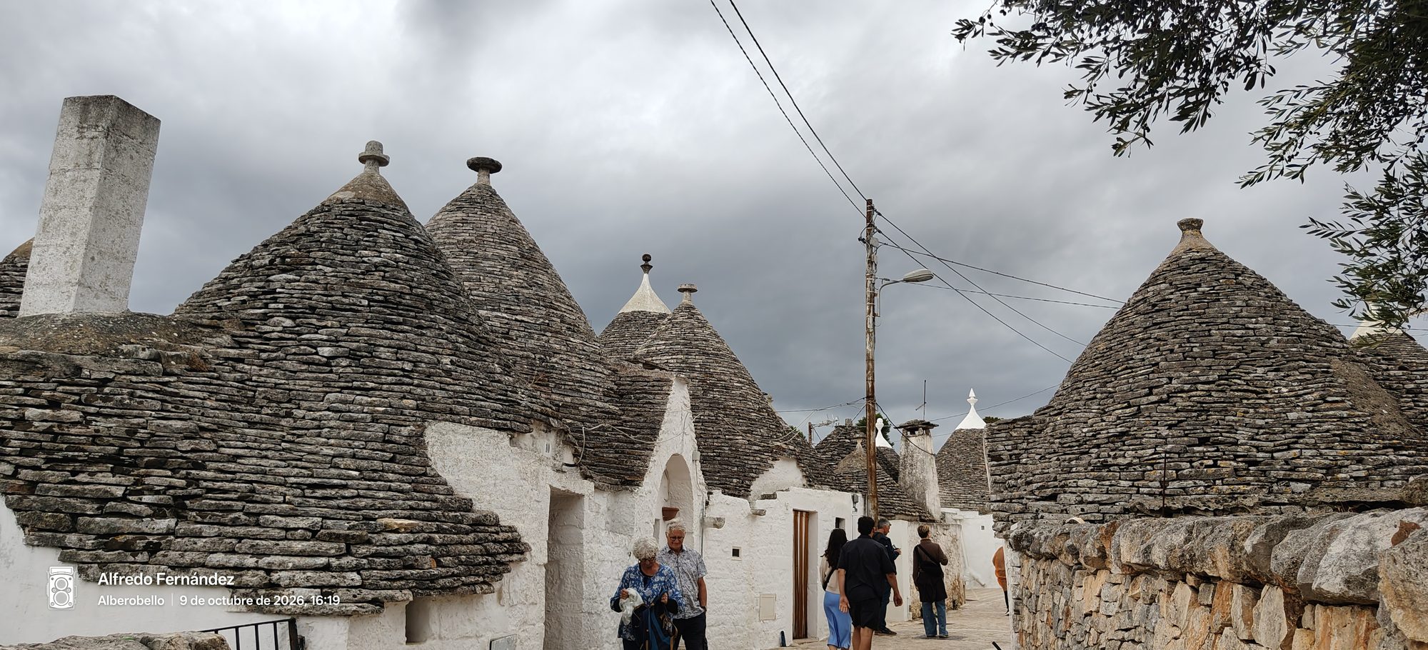 Casas tradicionales trulli con tejados cónicos de piedra bajo un cielo nublado en Alberobello.