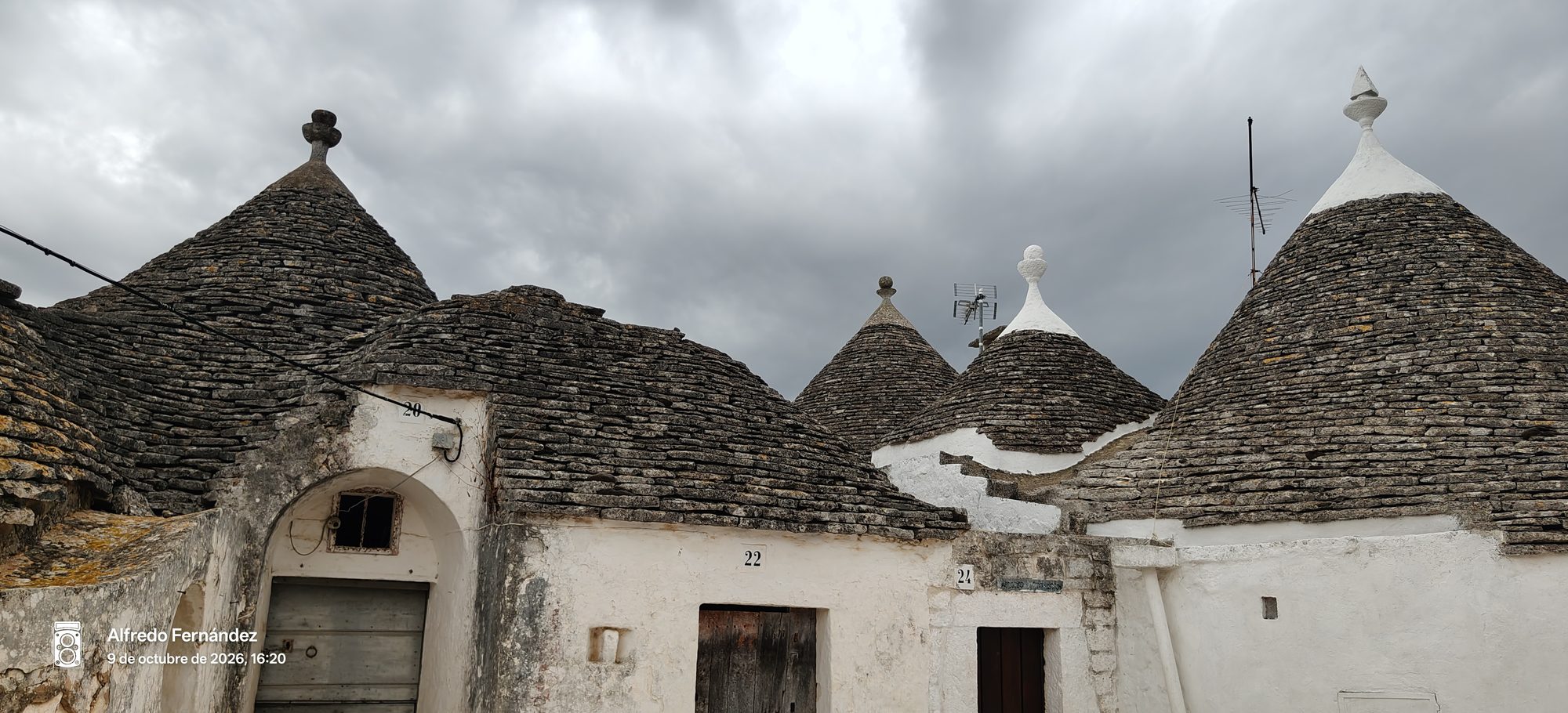 Tejados cónicos de piedra de tradicionales trulli bajo un cielo nublado en Alberobello.